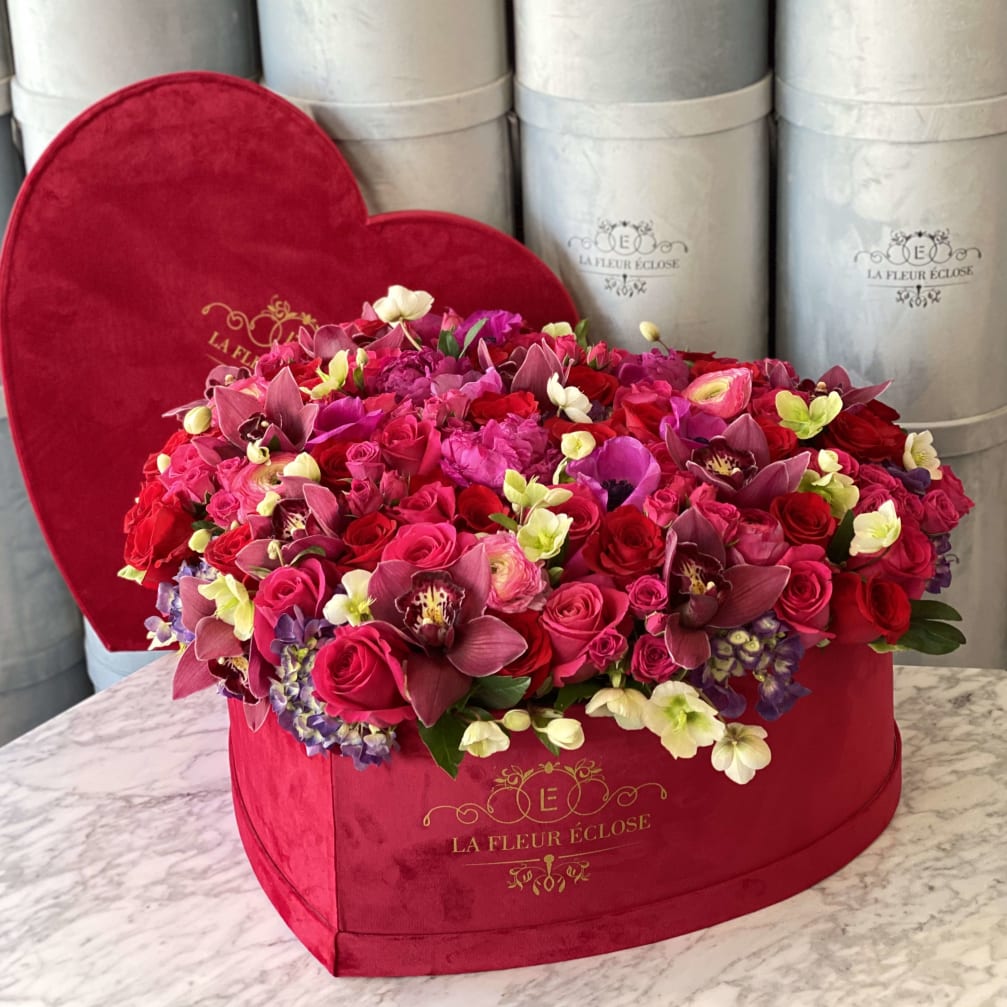Heart-shaped box filled with pink and red flowers
