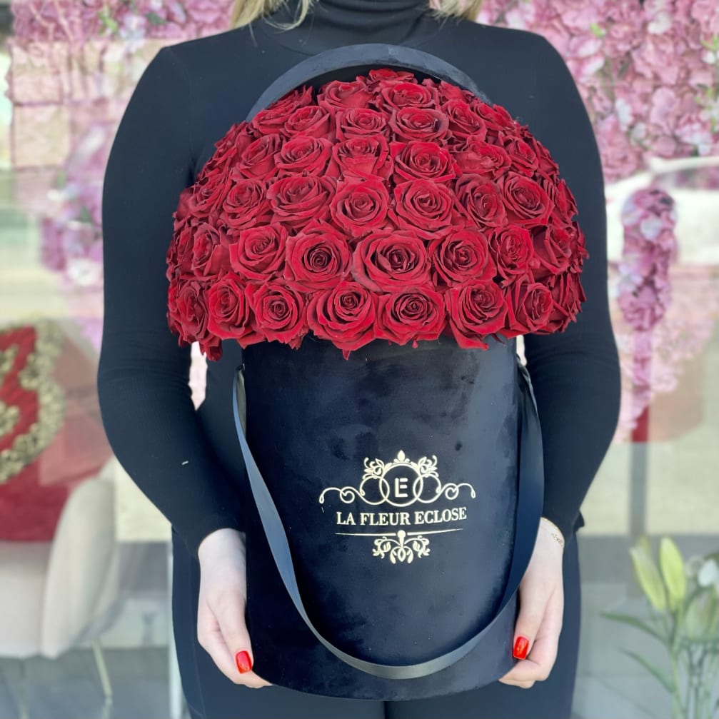 Large black hatbox filled with red roses