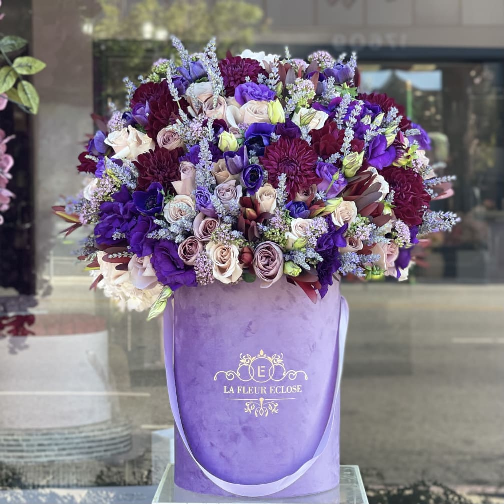 Large bouquet of purple, lavender, and blush flowers in a purple box