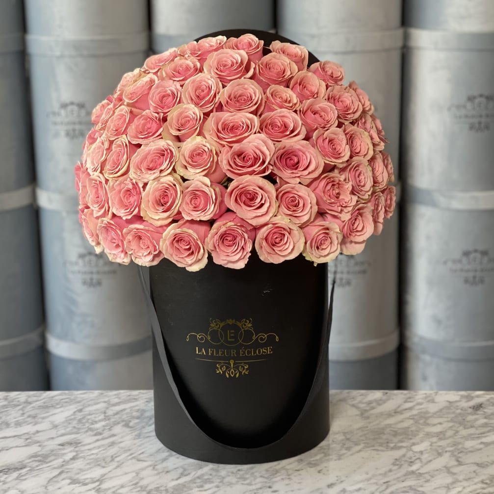 Round bouquet of pink roses in a black hat box