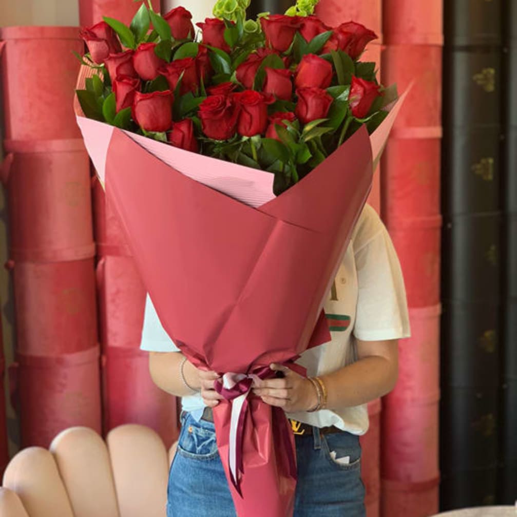 Large bouquet of red roses wrapped in pink paper