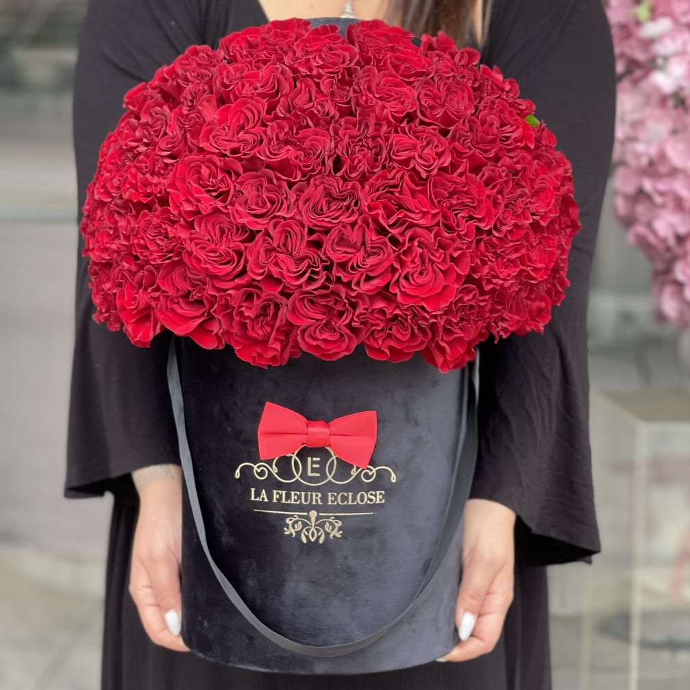 Large red rose bouquet in a black hatbox with a red bow