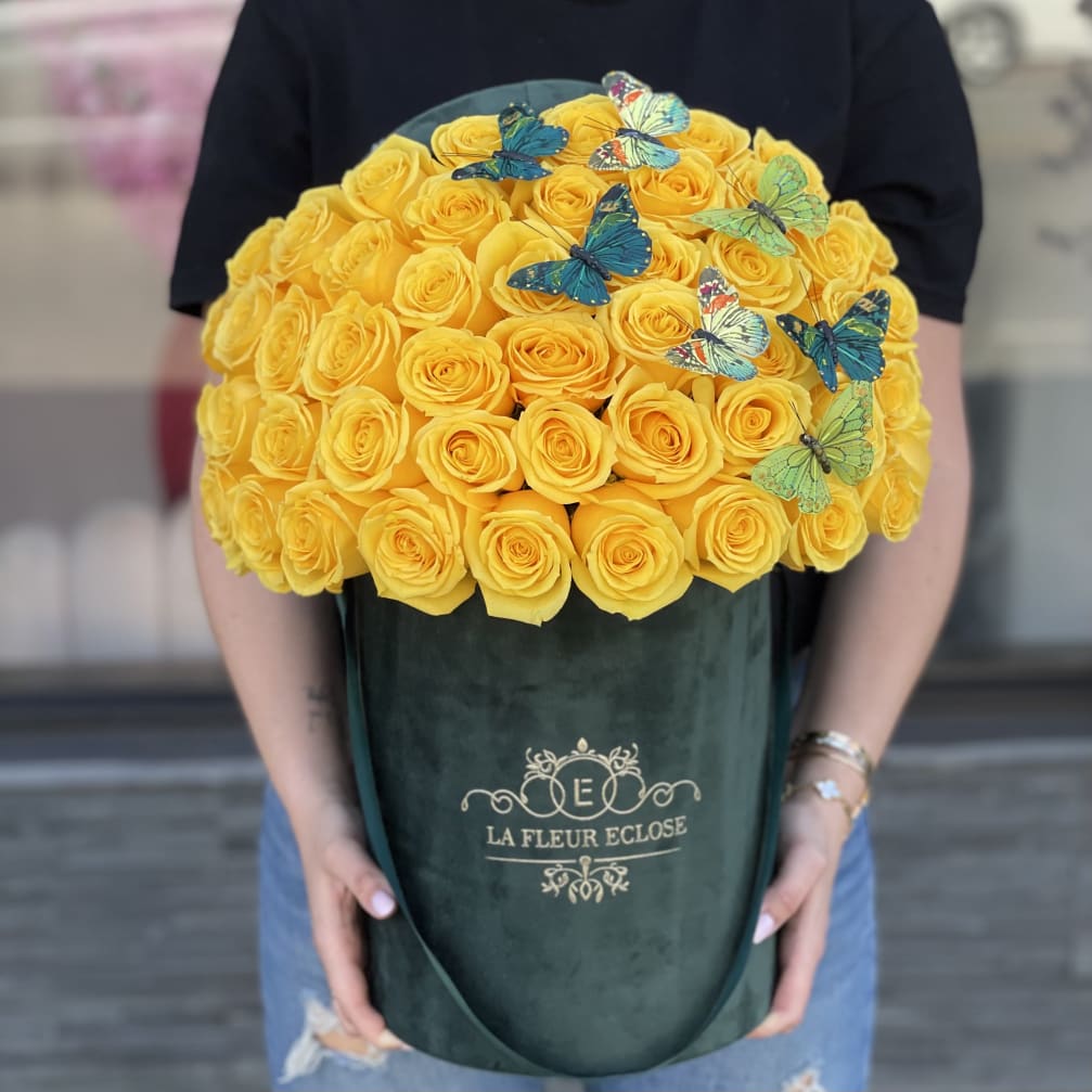 Large bouquet of yellow roses in a dark green box with butterfly decorations