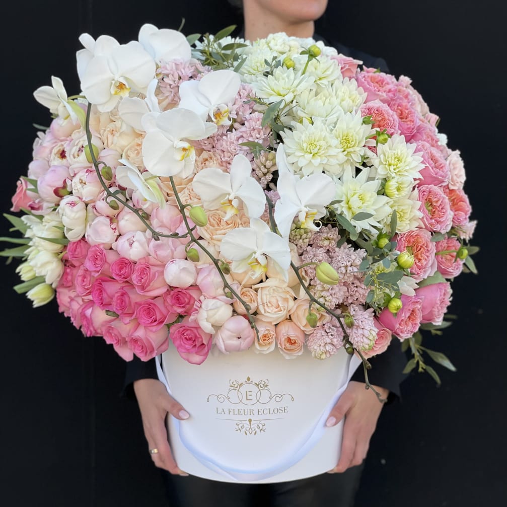 Large pink and white flower arrangement in a white hatbox