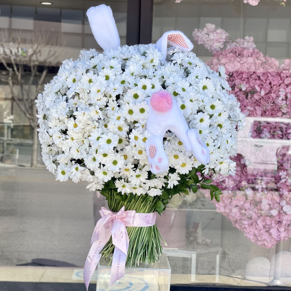 Bouquet of white daisies with a pink plush bunny