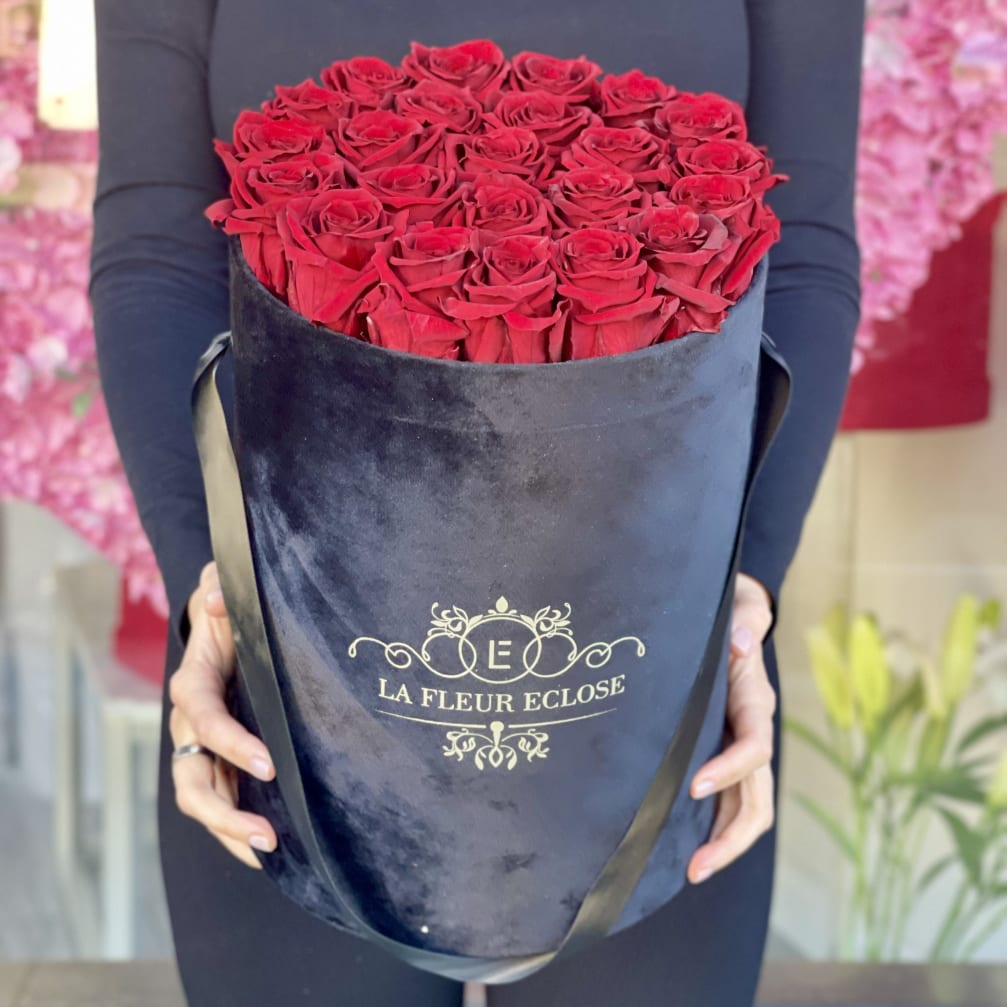 Large bouquet of red roses in a black round box