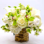 White and green floral arrangement in a birch-pattern vase