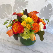 Colorful bouquet of roses, tulips, and hydrangeas in a green vase