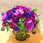 Purple and pink flower arrangement in a glass vase