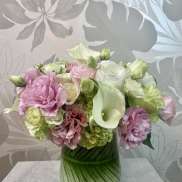 Pink and white flowers arranged in a green striped vase