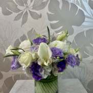 Purple and white bouquet in a glass vase