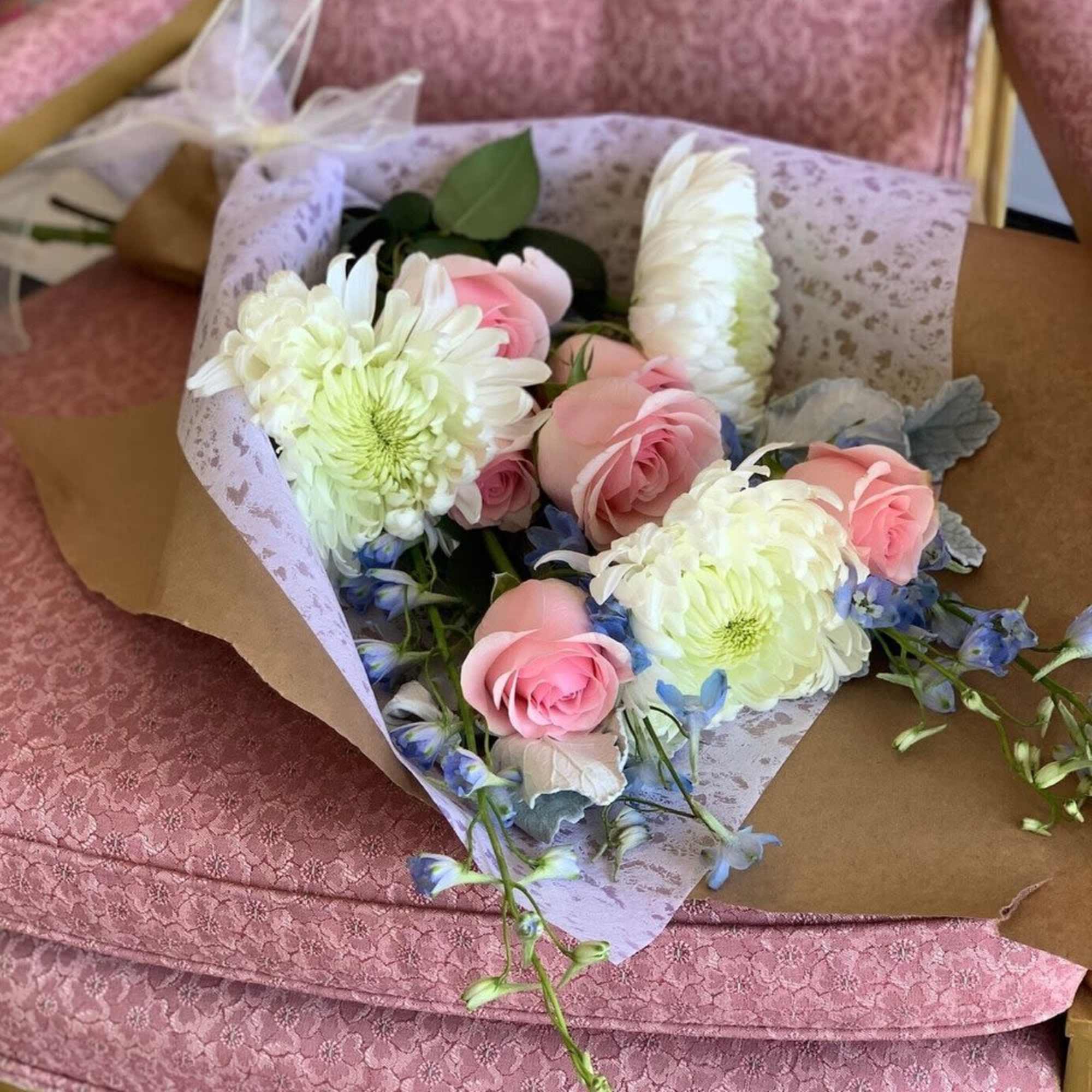 Pink and white bouquet with roses and chrysanthemums wrapped in paper