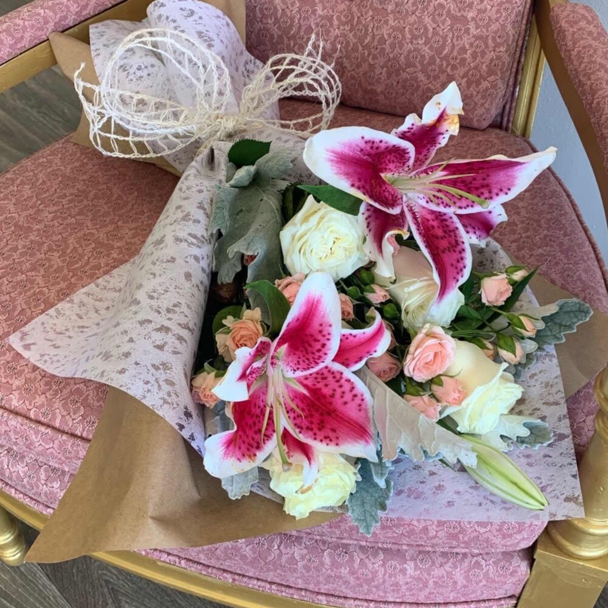 Bouquet of pink lilies and pale roses wrapped in paper