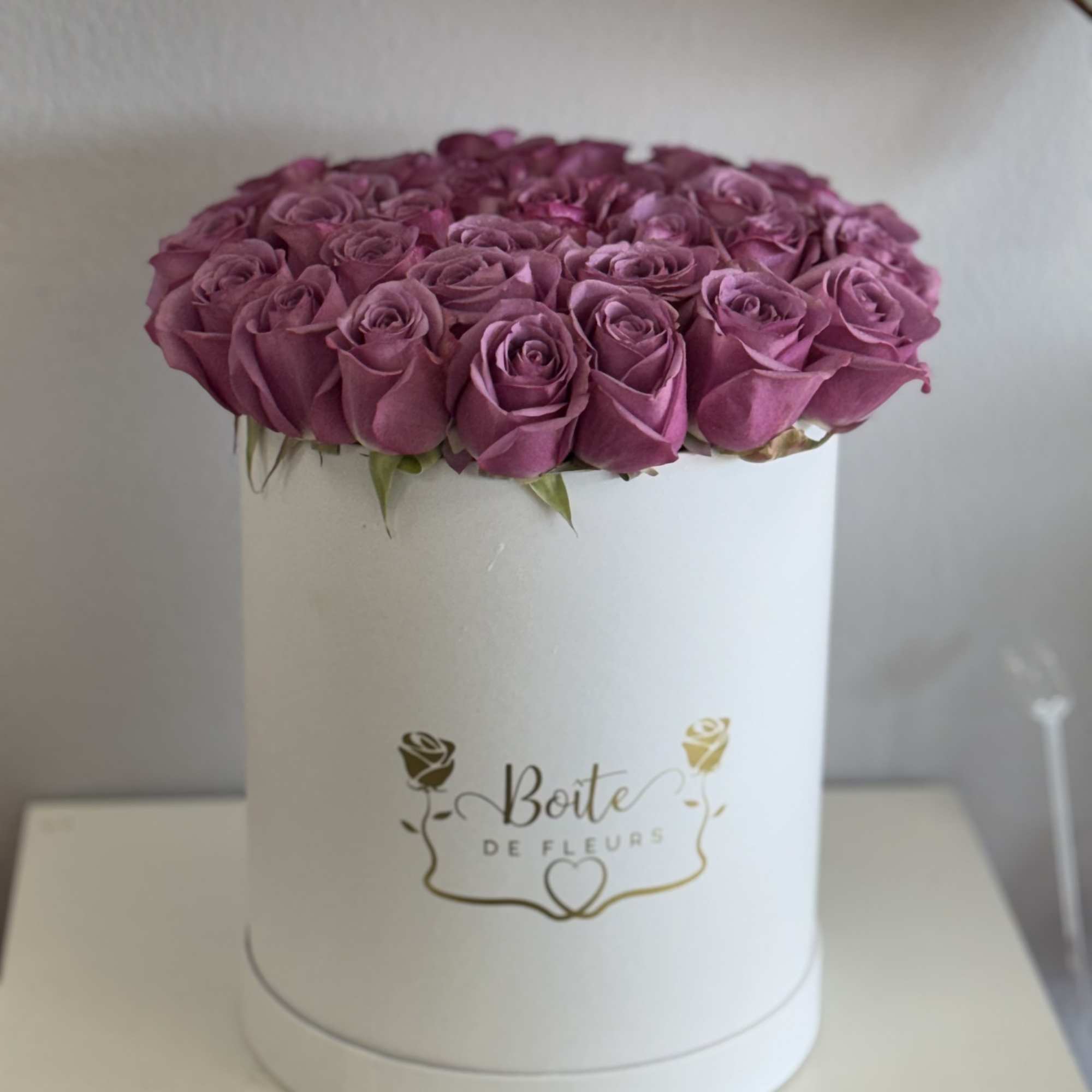 Pink roses arranged in a white round box
