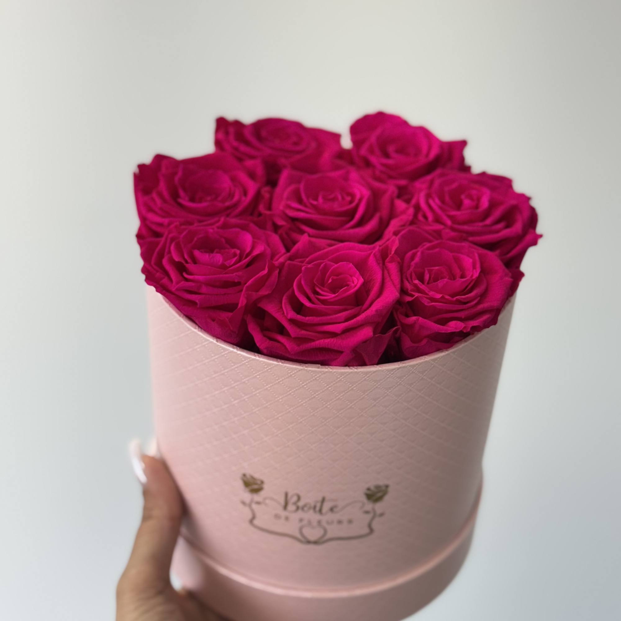Pink roses arranged in a pale pink round box