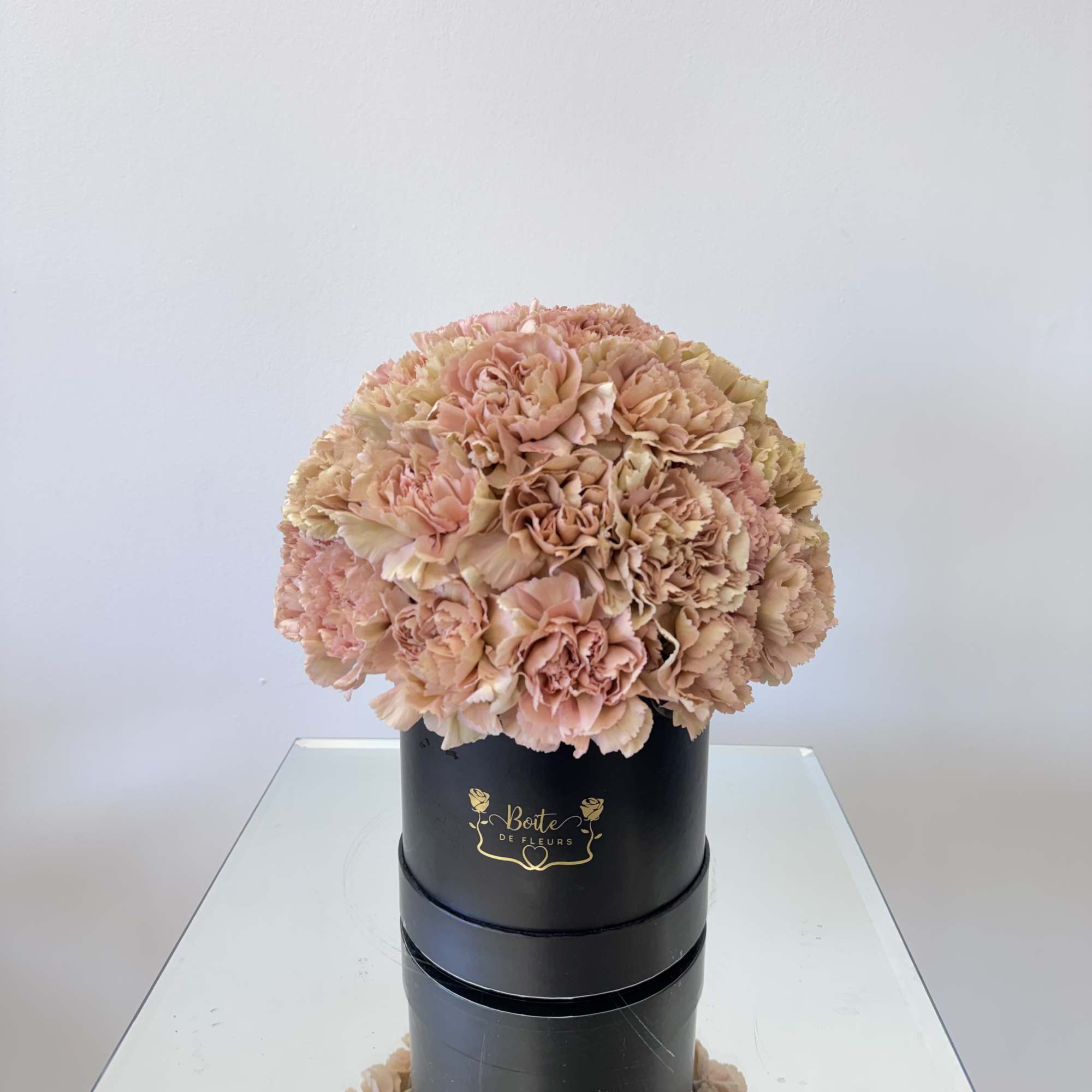 Peach carnation bouquet in a black hatbox