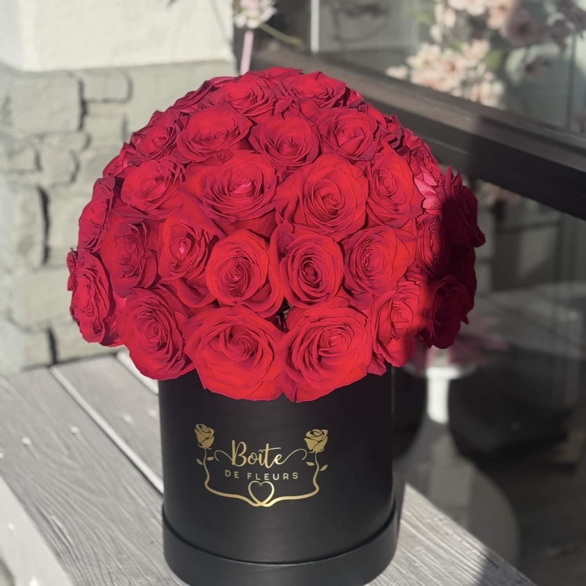 Red roses arranged in a black round box