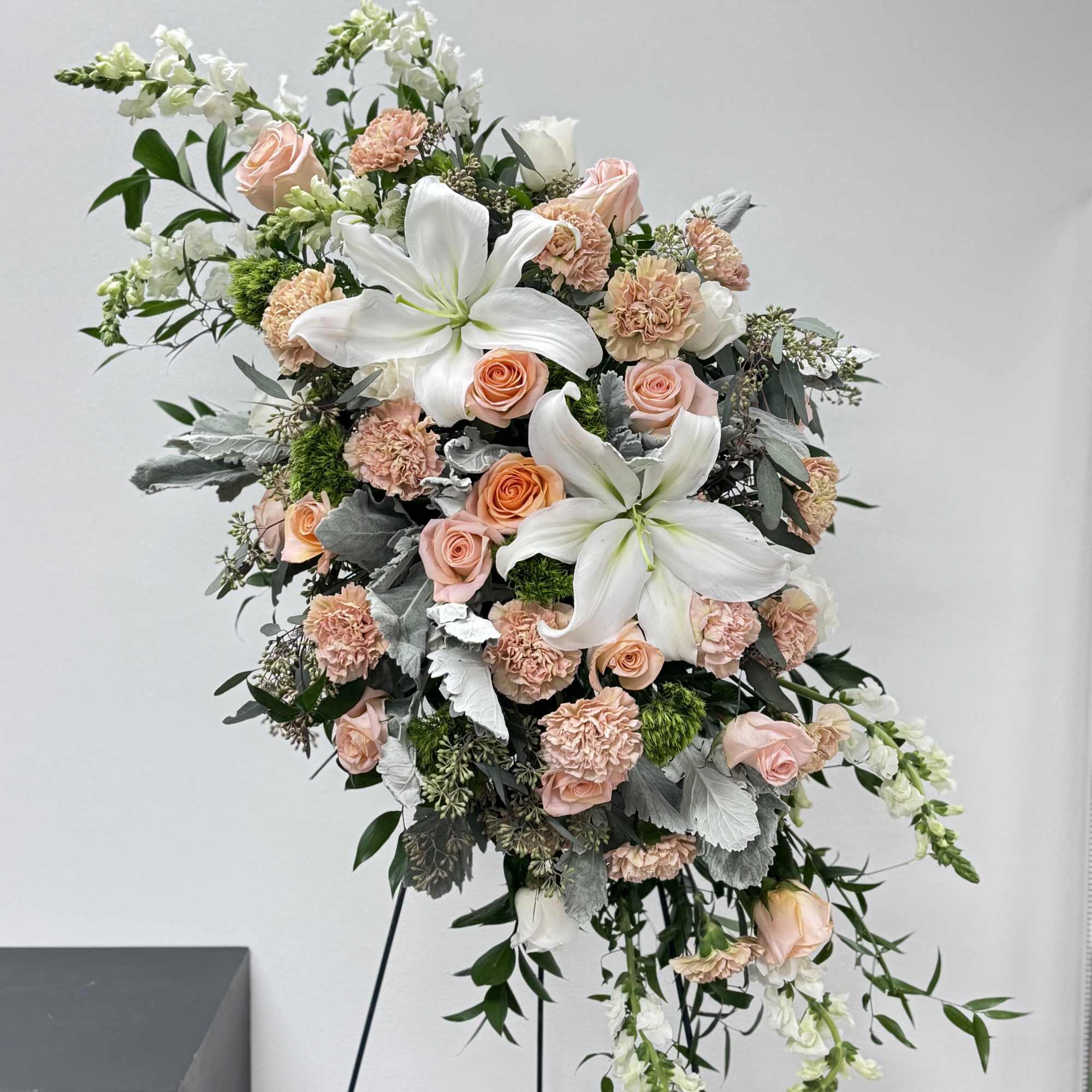 Tall floral spray with white lilies and blush roses on a stand