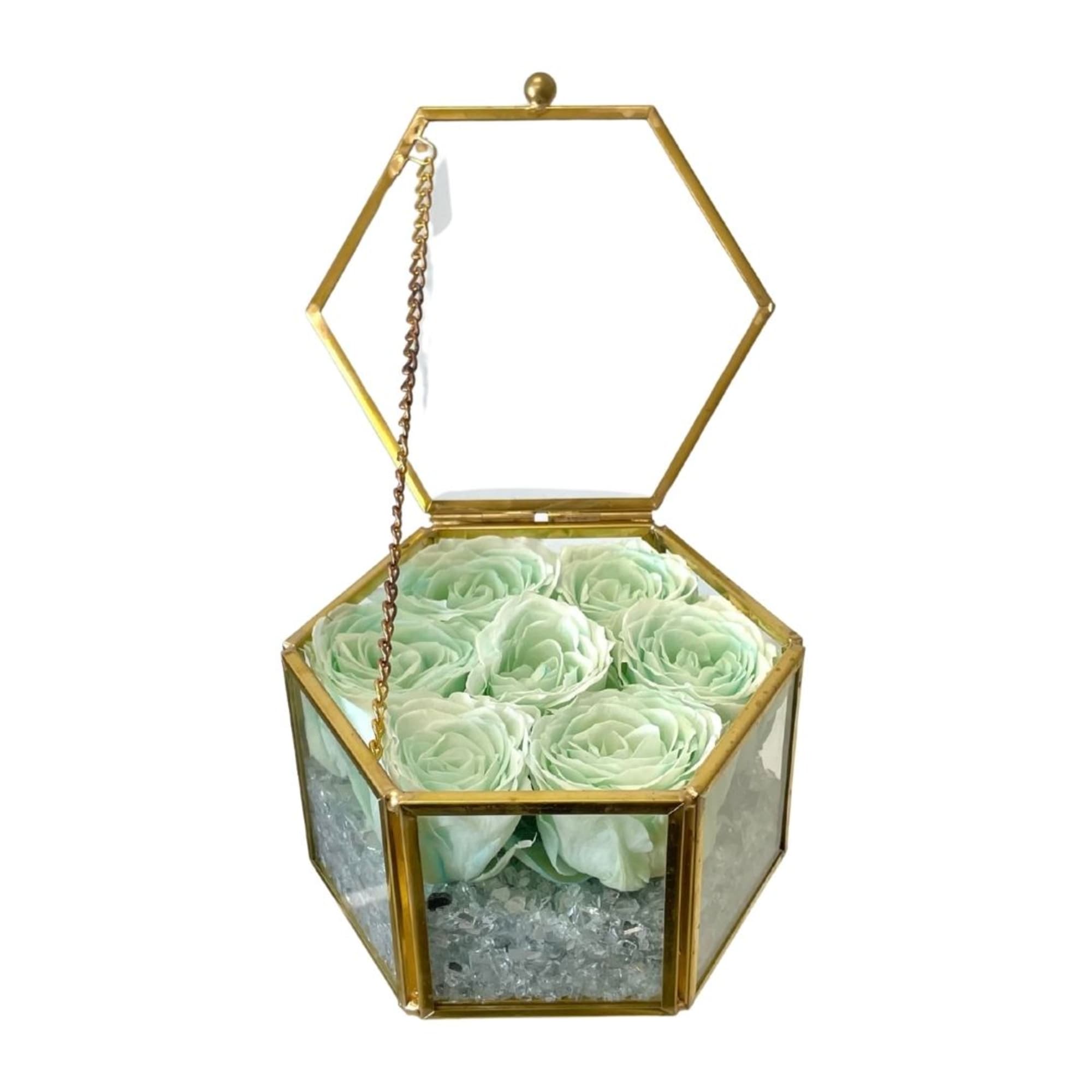 Mint green roses in a gold hexagonal glass box with an open lid