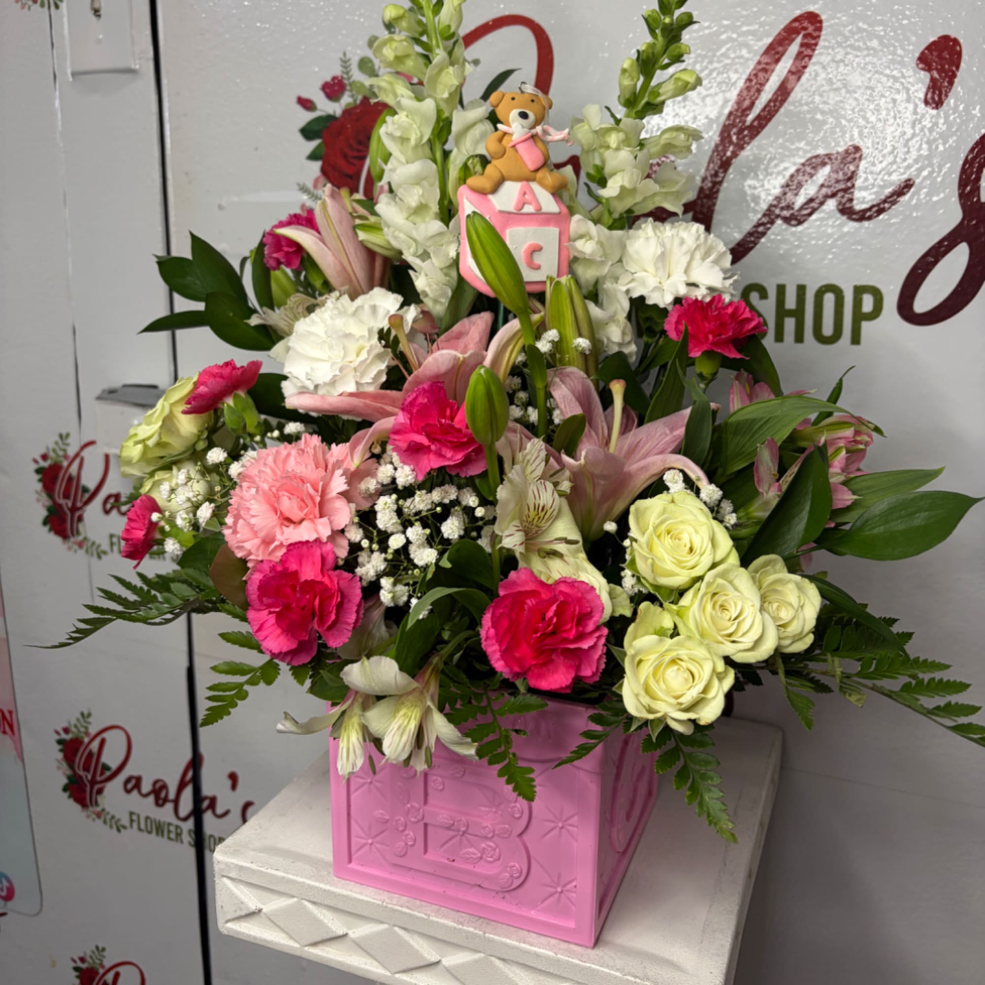 Pink and white floral arrangement in a pink box with a teddy bear topper, photo 2 of 2