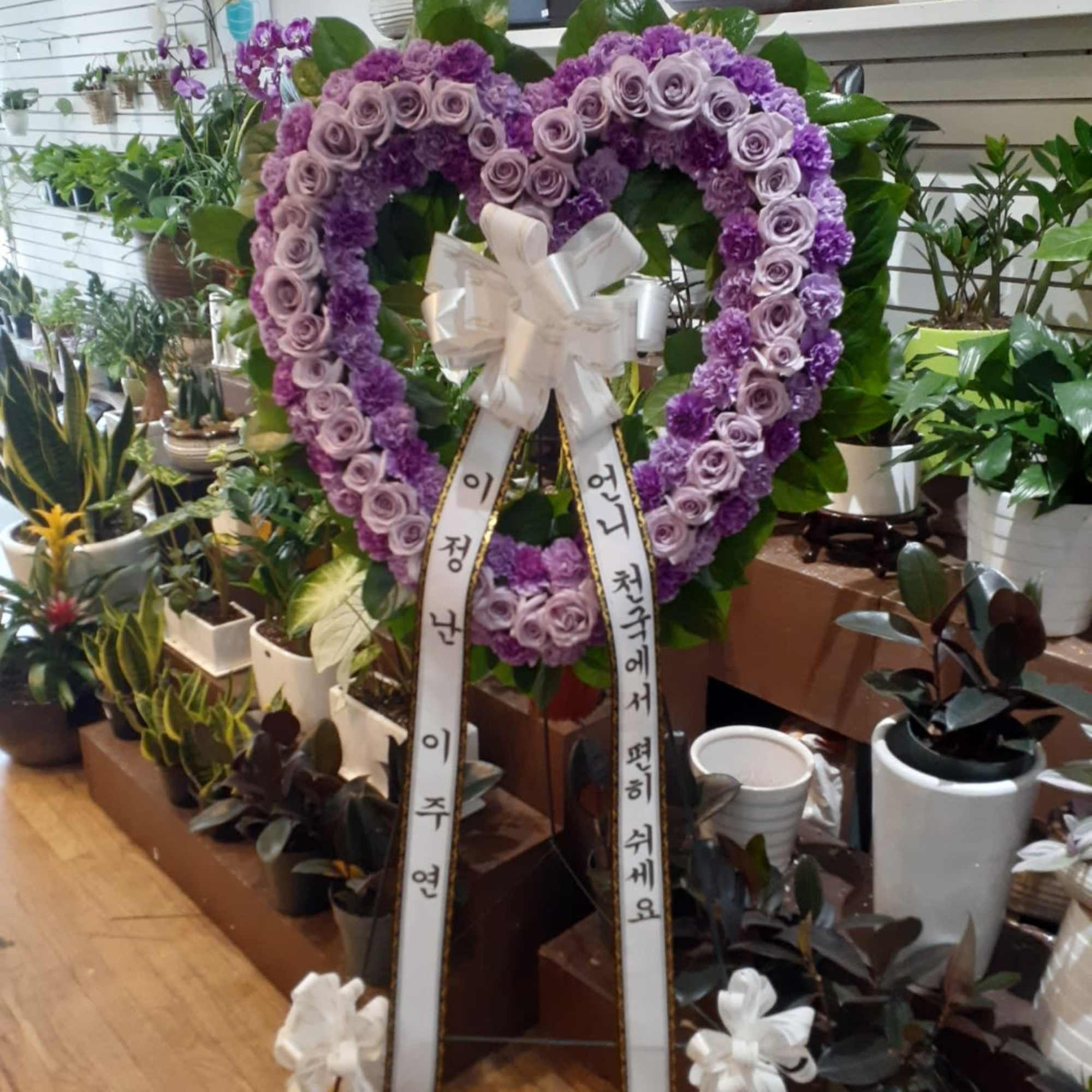 Purple heart-shaped floral wreath with ribbon streamers