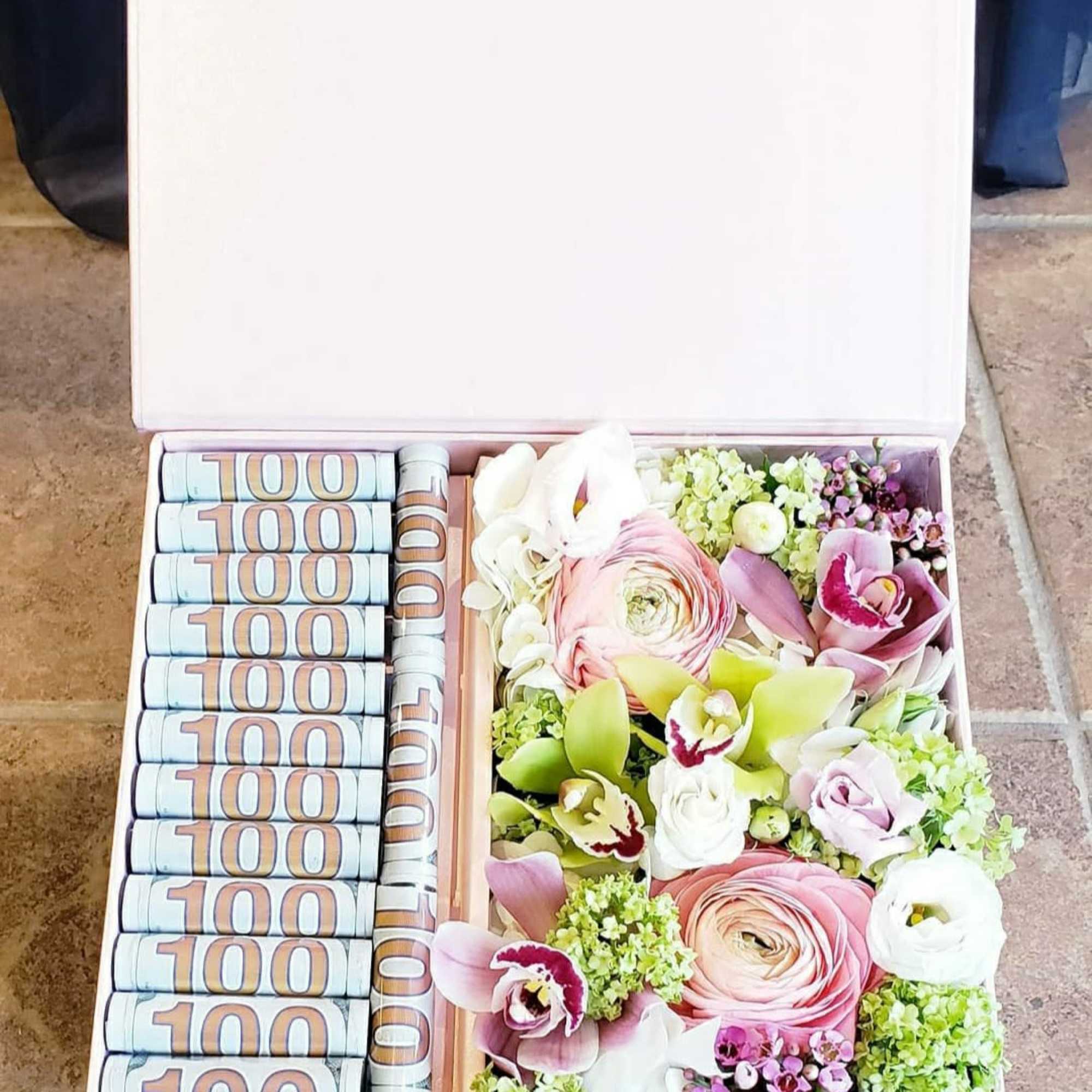 Gift box with rolled cash and pastel flowers