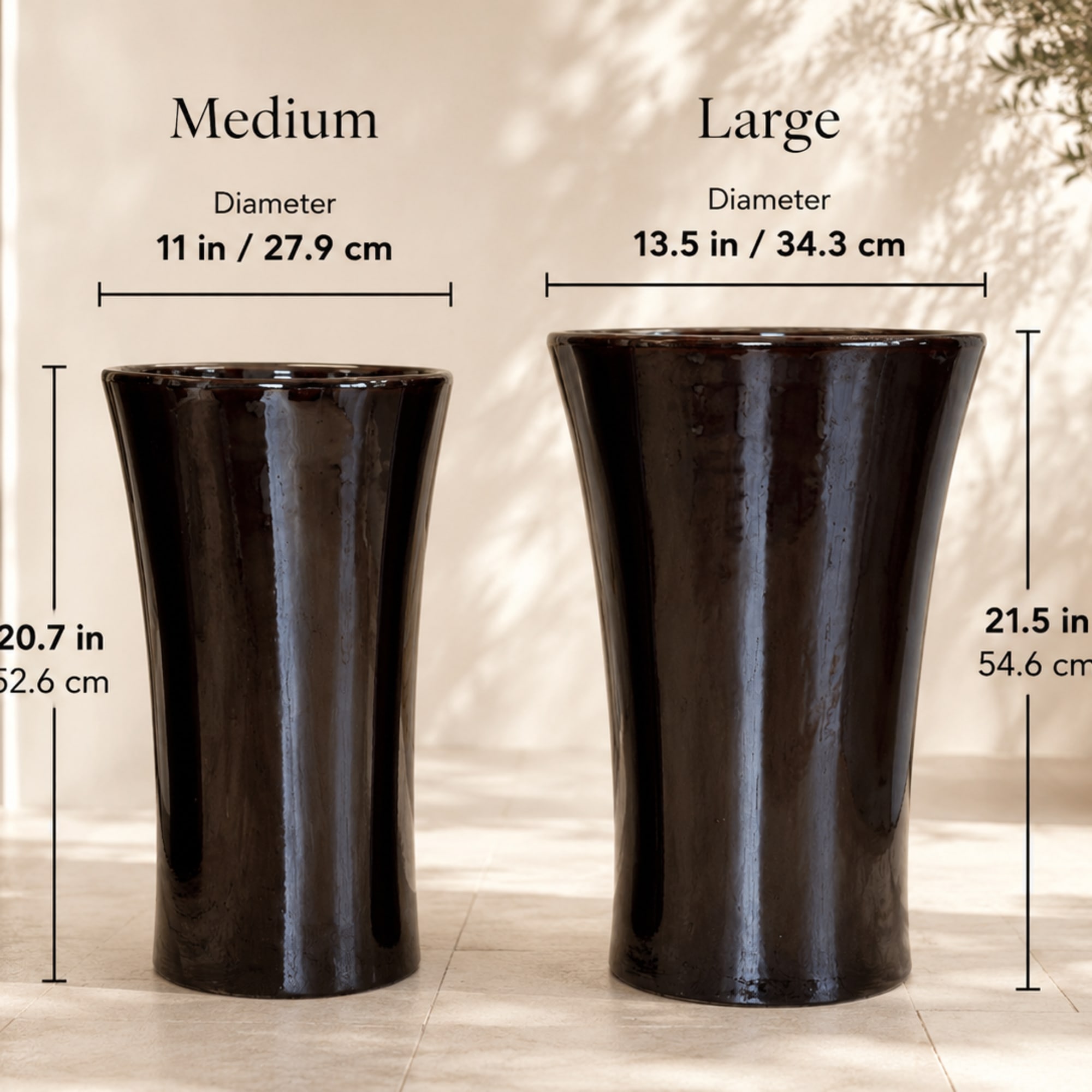 Two dark ceramic pedestal vases with size labels on a showroom wall.