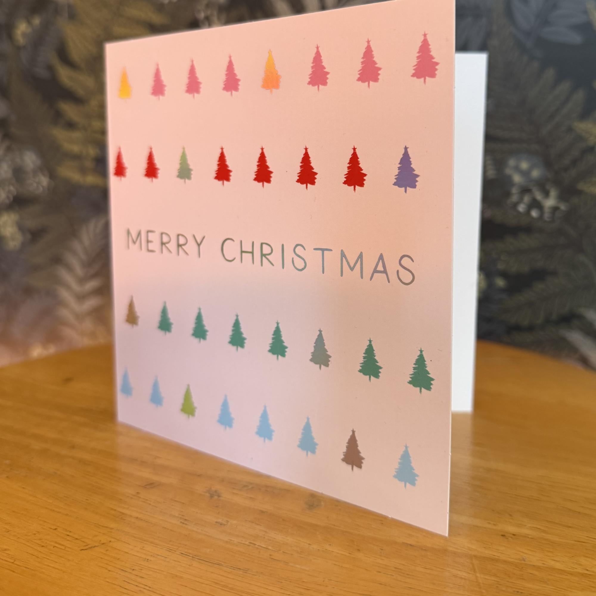 A pink Christmas card with multicolored tree icons and "Merry Christmas" text.