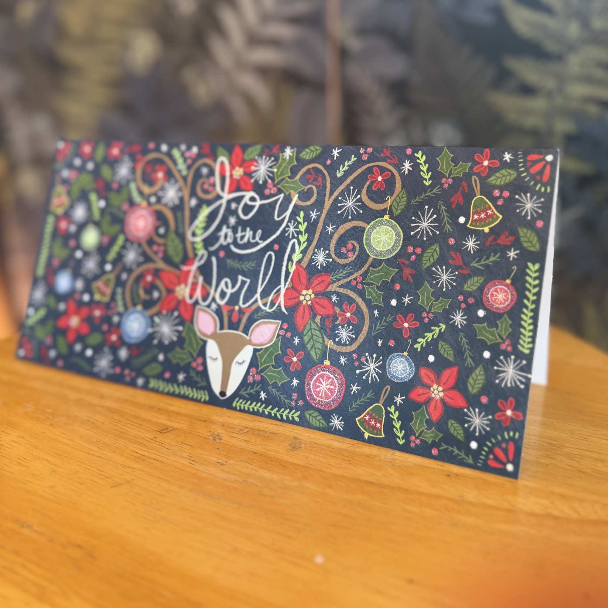 Holiday card with a deer and "Joy to the World" text