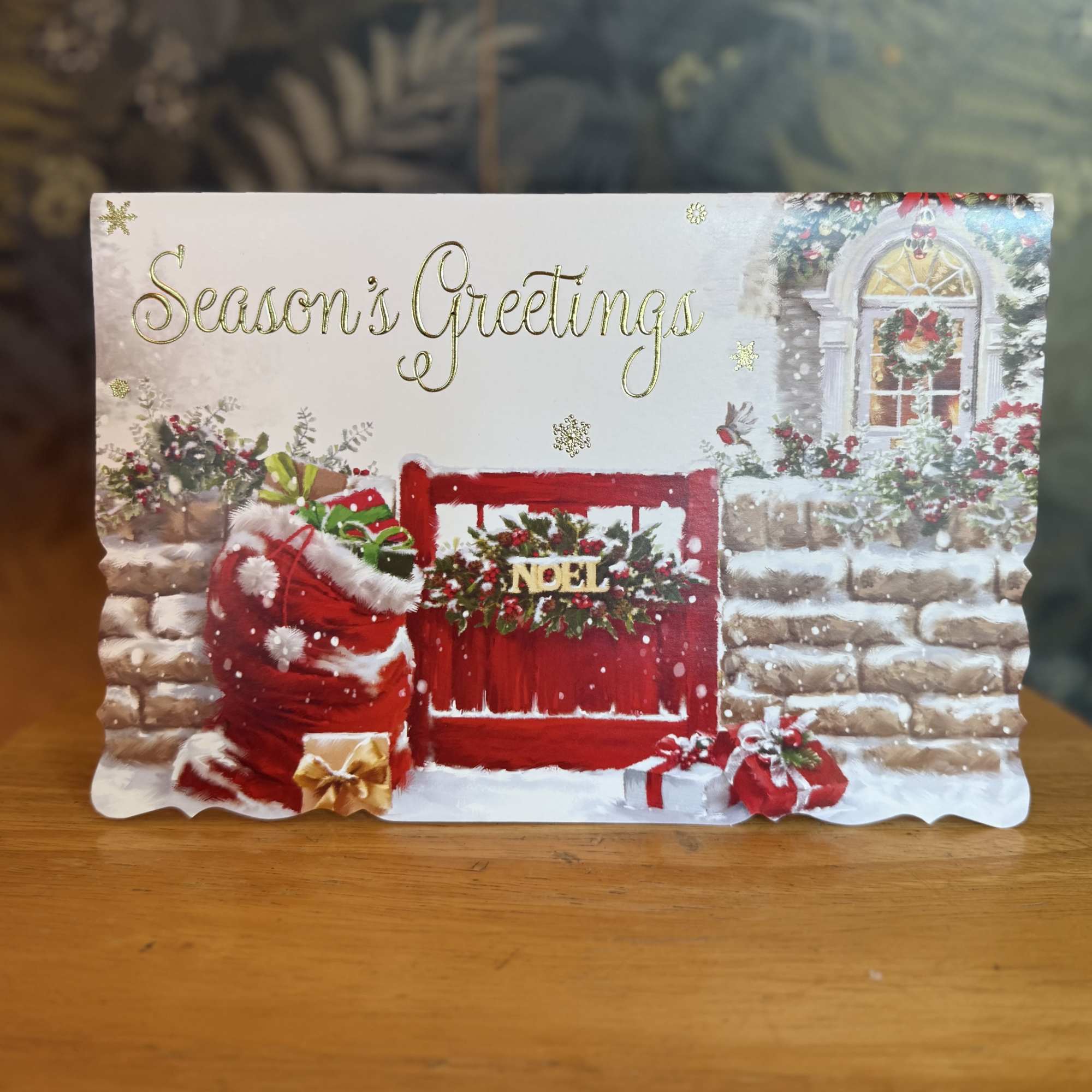 Season's Greetings holiday card with a Christmas scene and gift bags