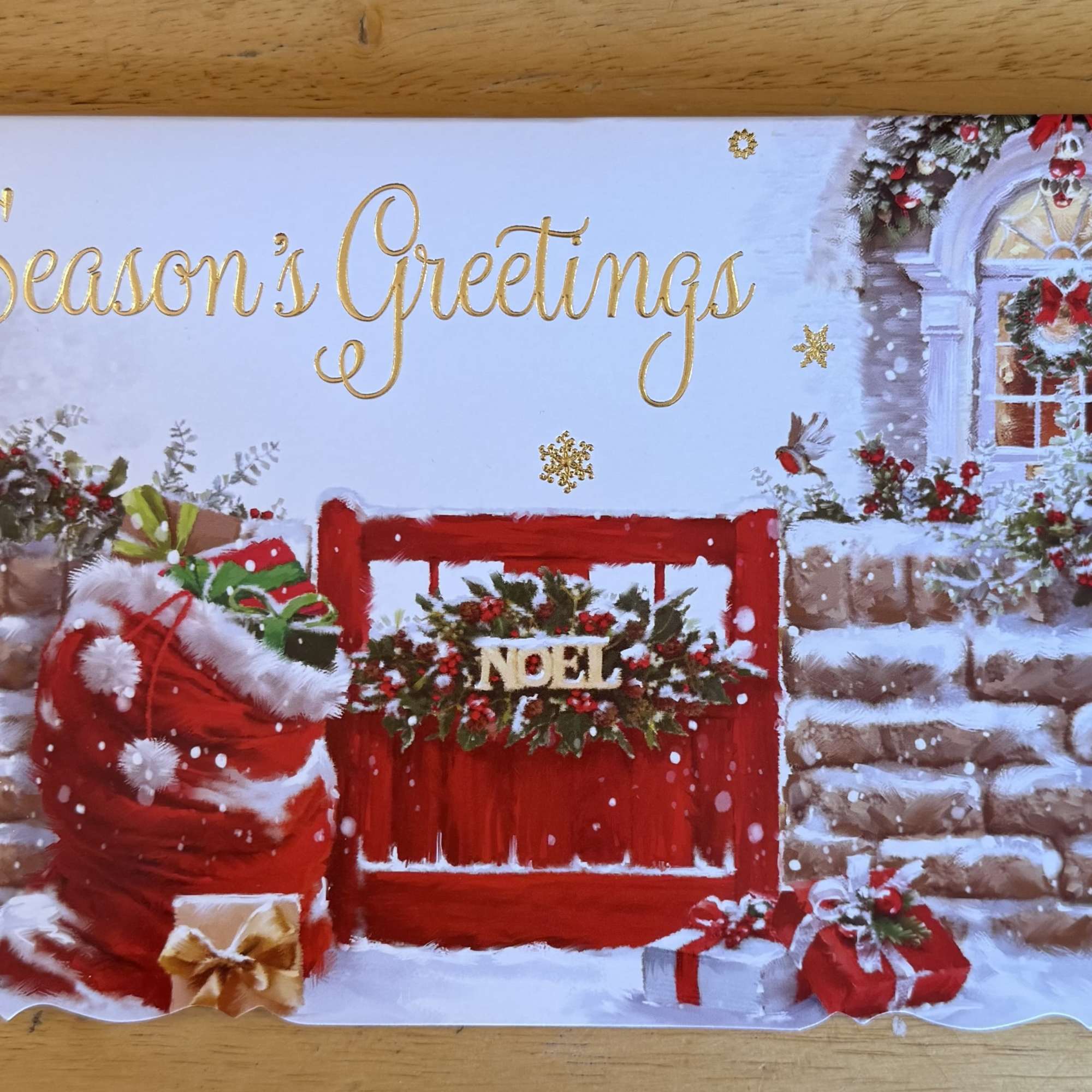 Season's Greetings holiday card with a snowy red door and gift bags