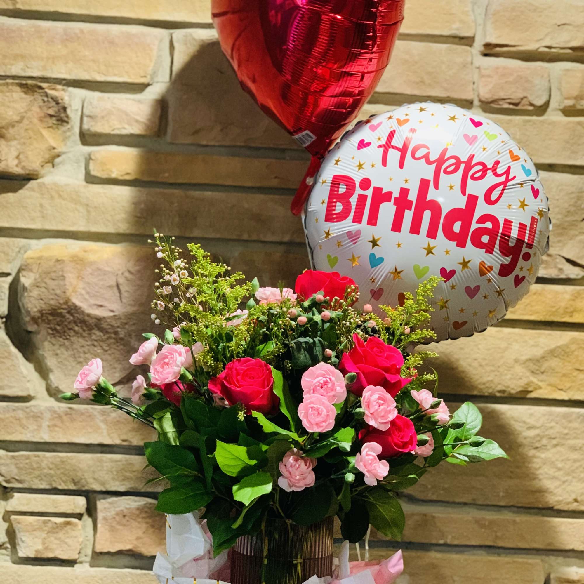Bouquet of pink and red roses with birthday balloons
