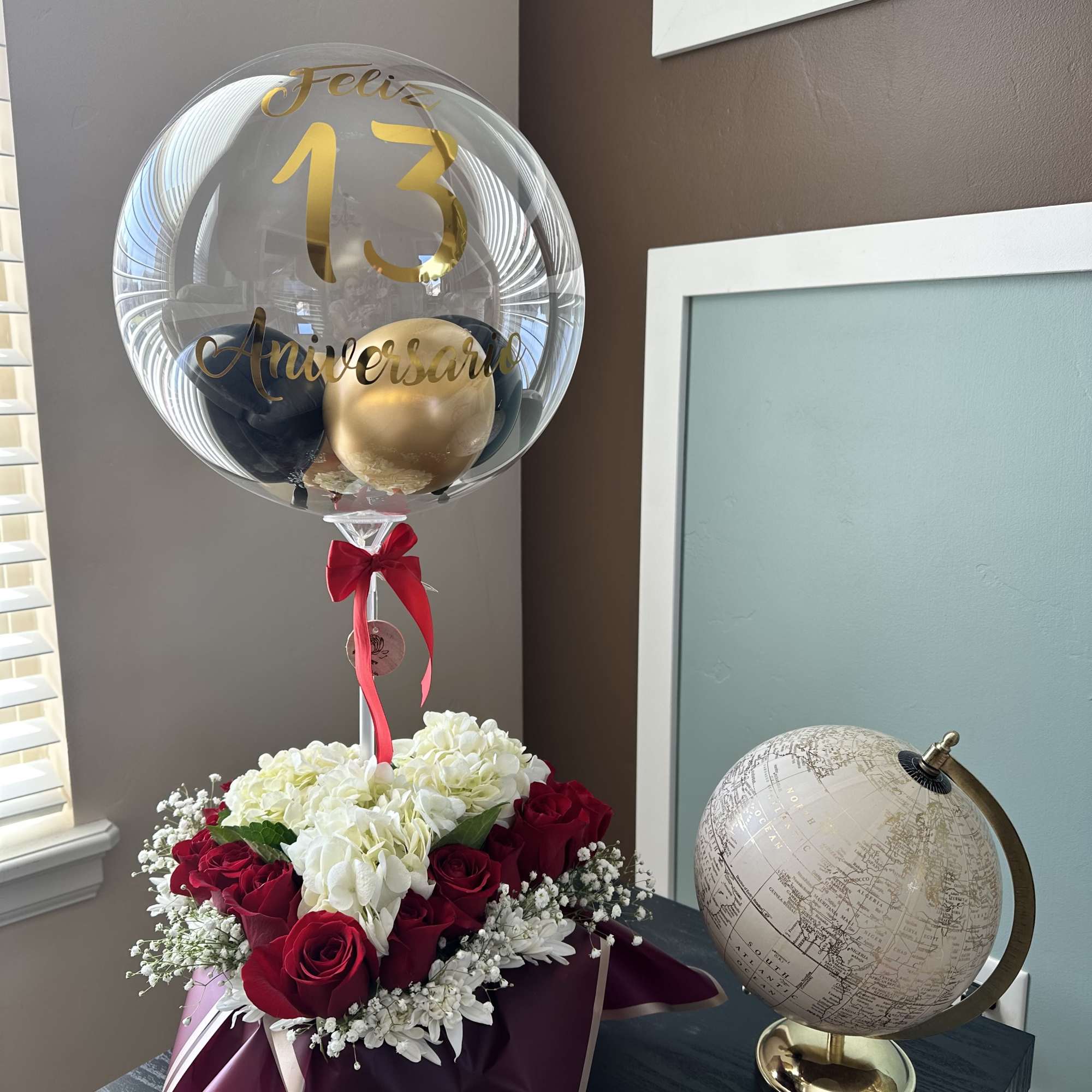 Red roses and white hydrangeas with a clear anniversary balloon