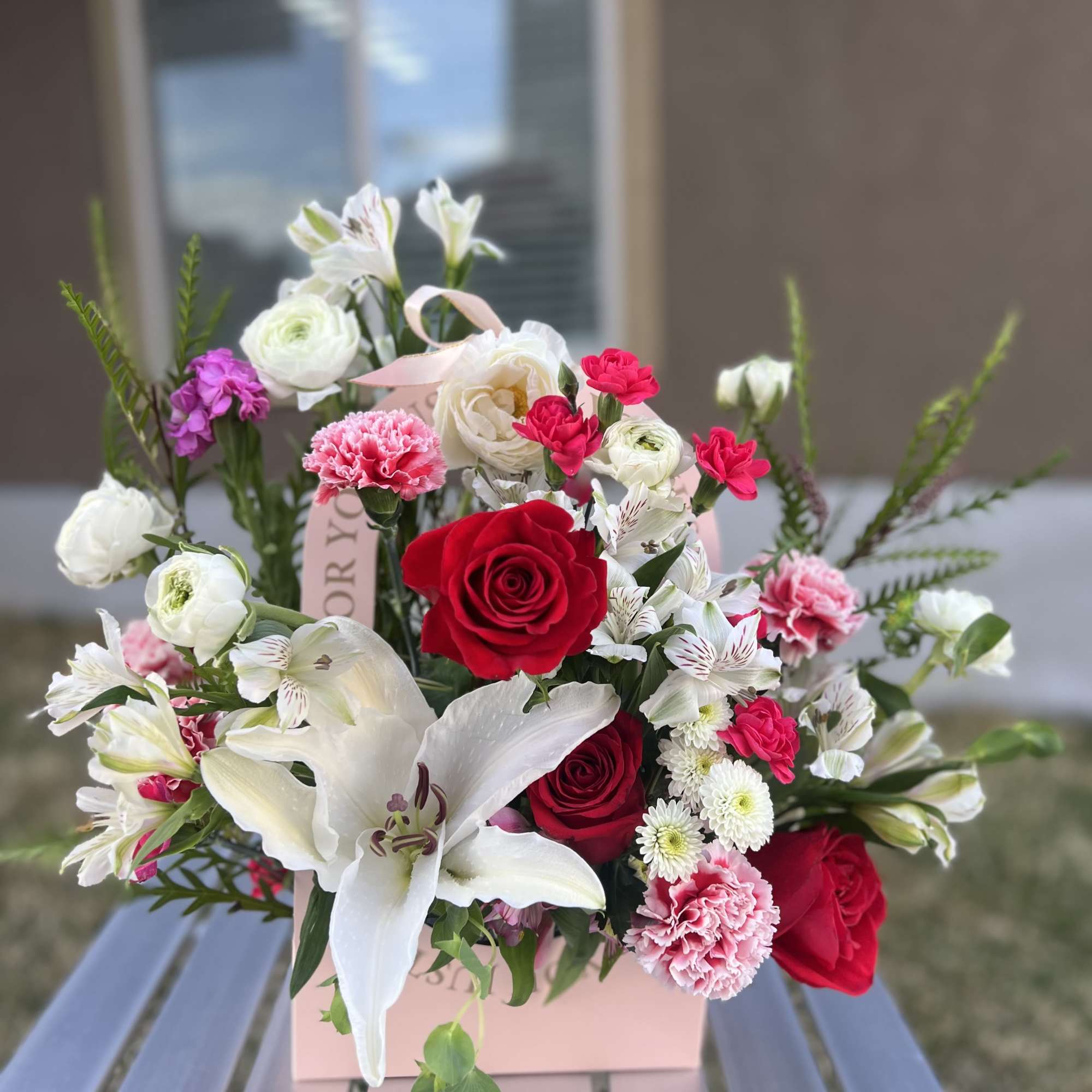 Bouquet of red and white flowers in a pink gift box