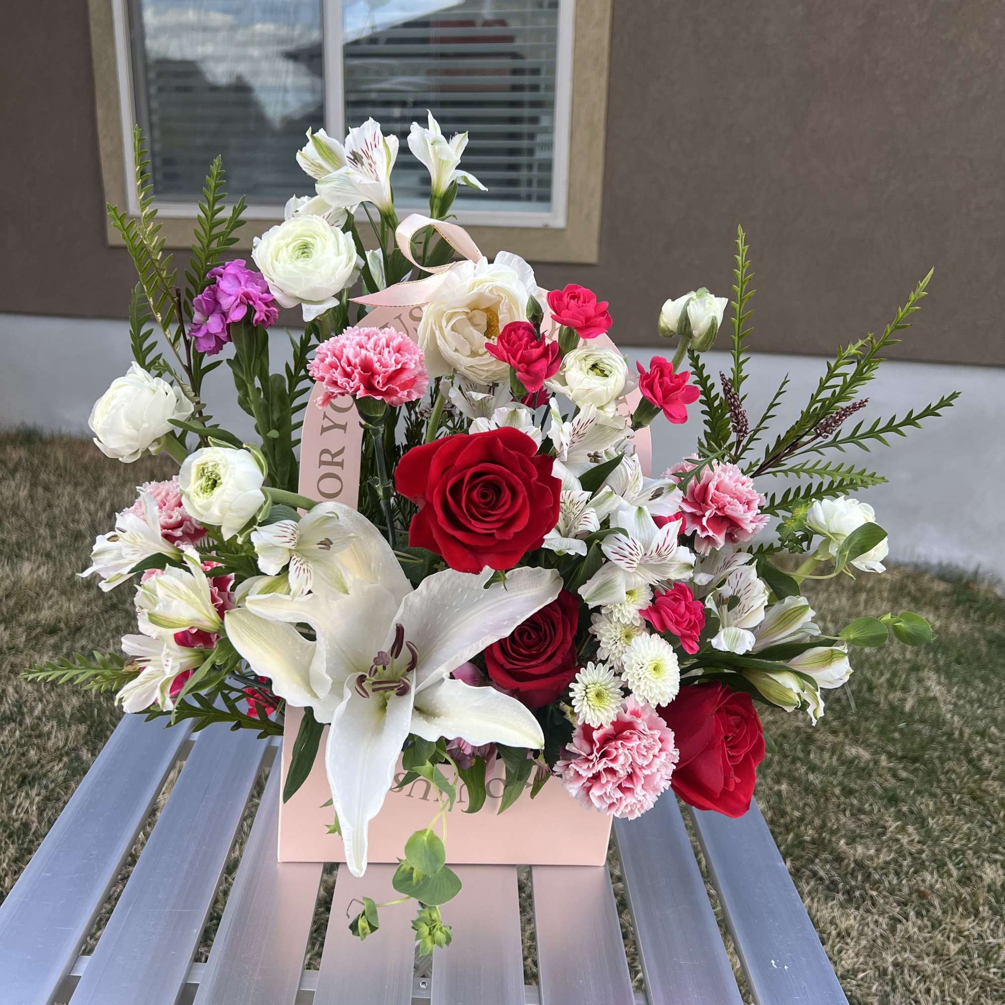 Pink and red bouquet with white lilies and roses in a pink box