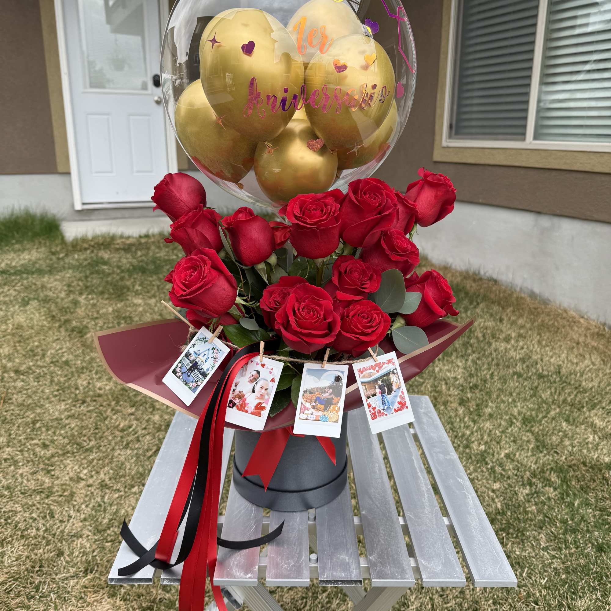 Red roses with a clear balloon and gold balloons on top