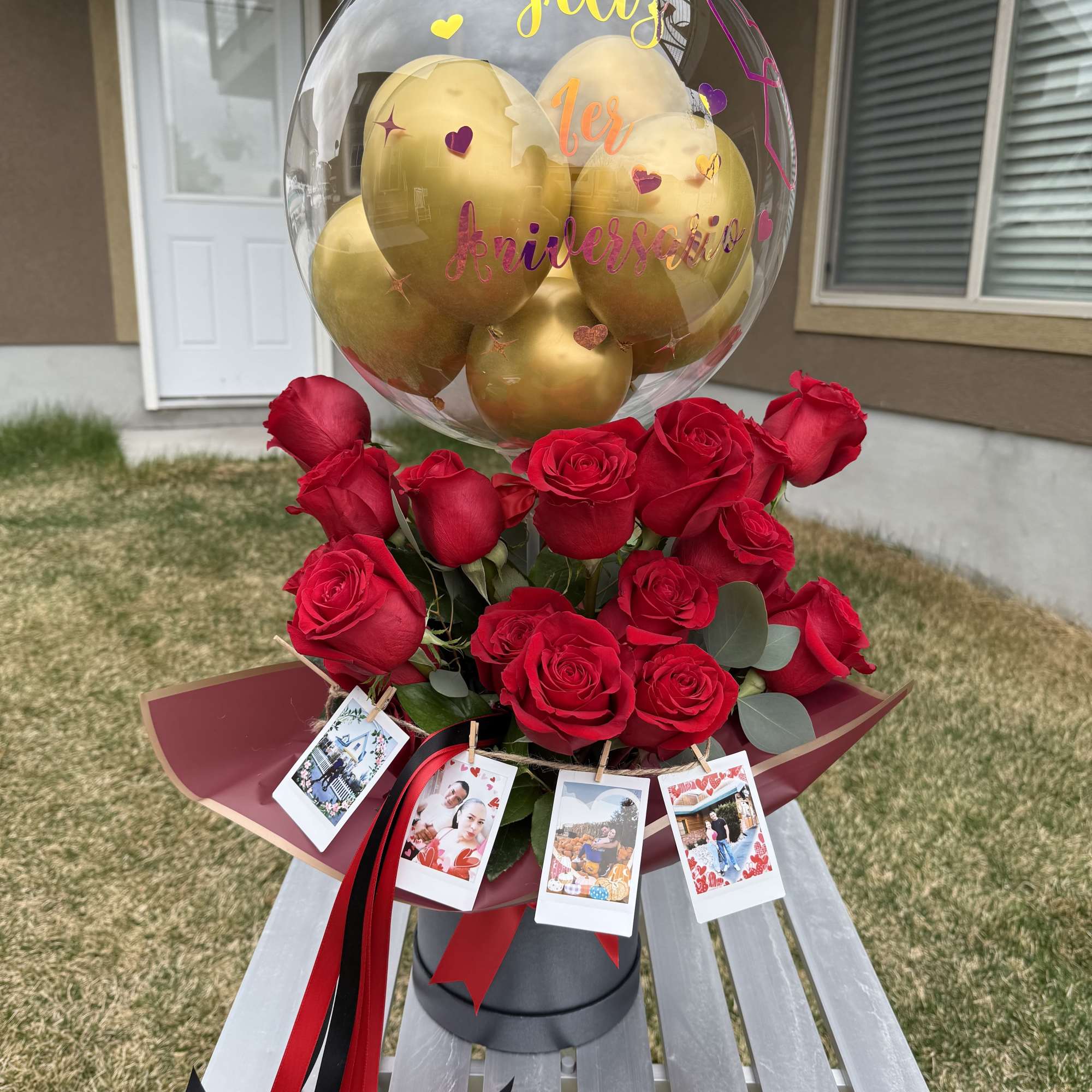 Red roses with a clear balloon of gold balloons and photo tags