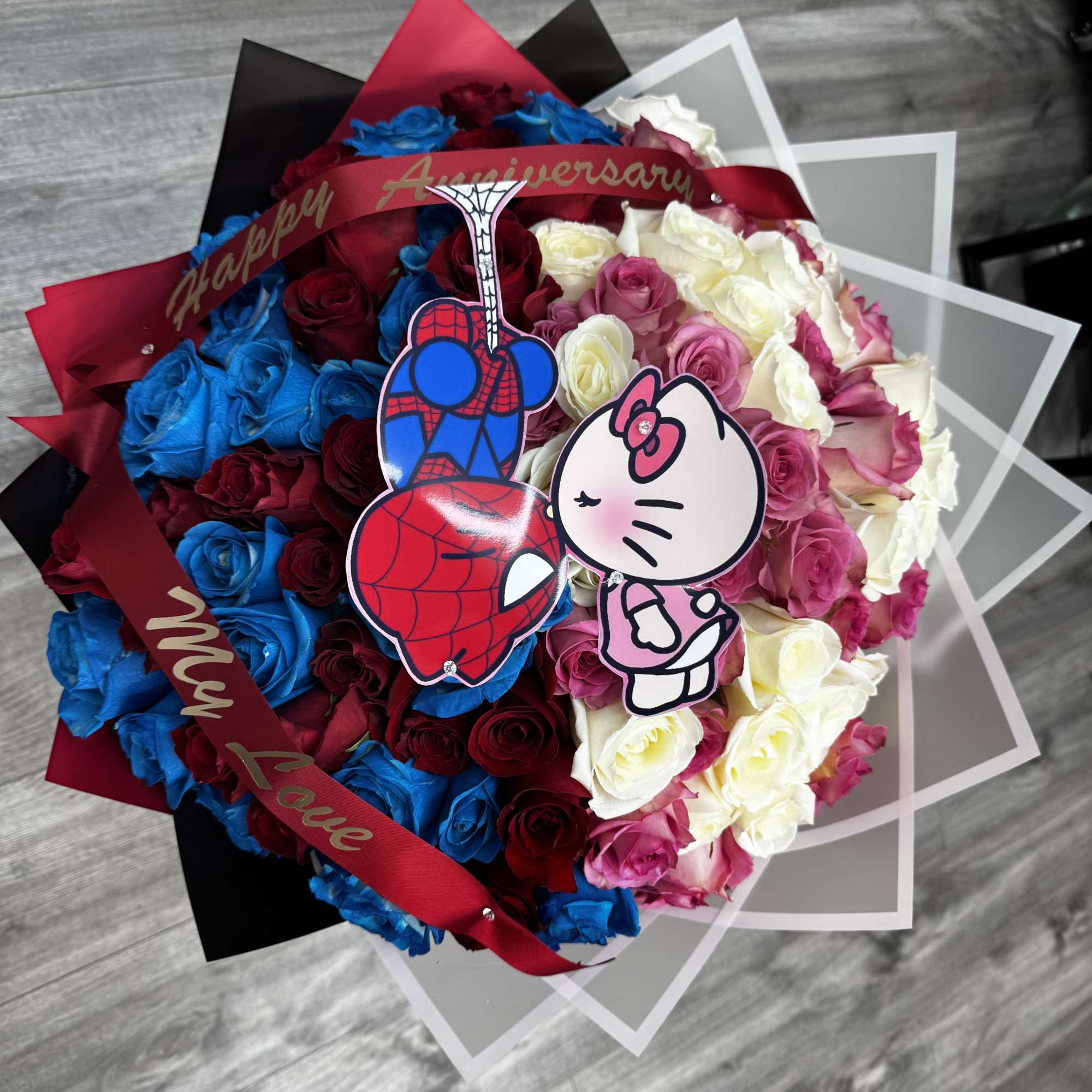 Bouquet of red, blue, white, and pink roses with cartoon toppers