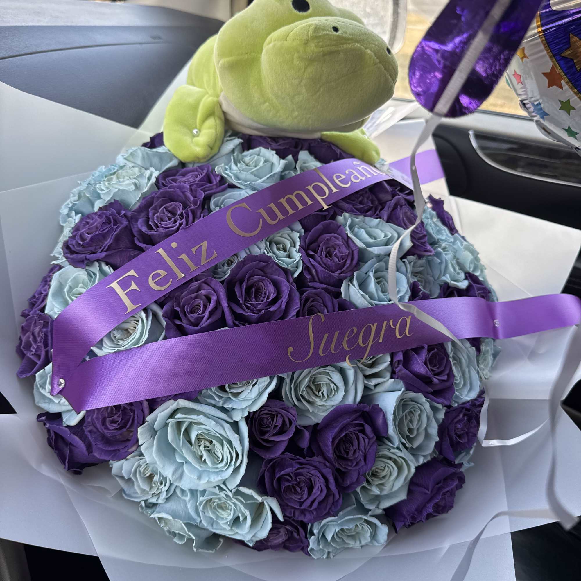 Purple and blue rose bouquet with a plush frog and ribbon