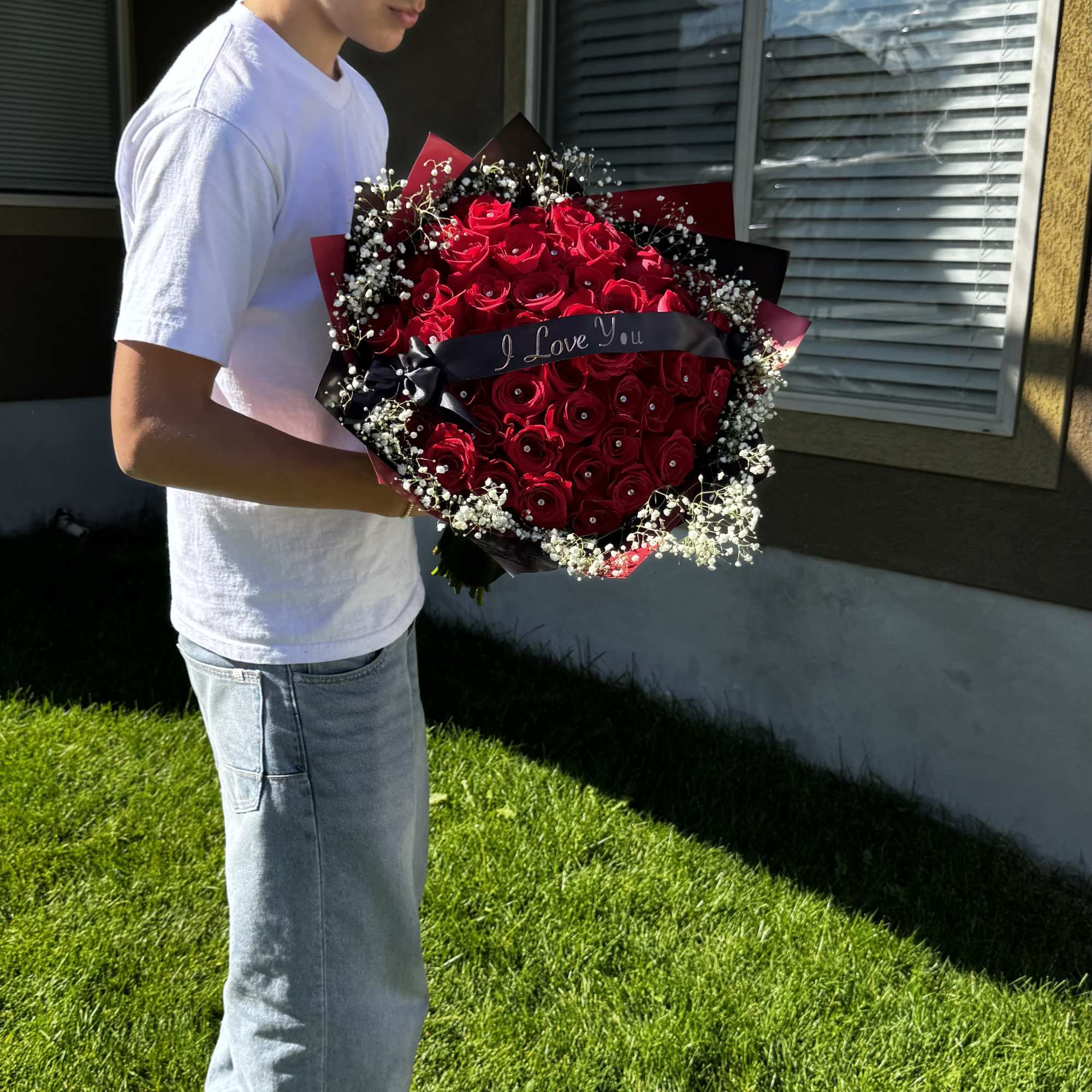 Large bouquet of red roses with baby's breath and a ribbon