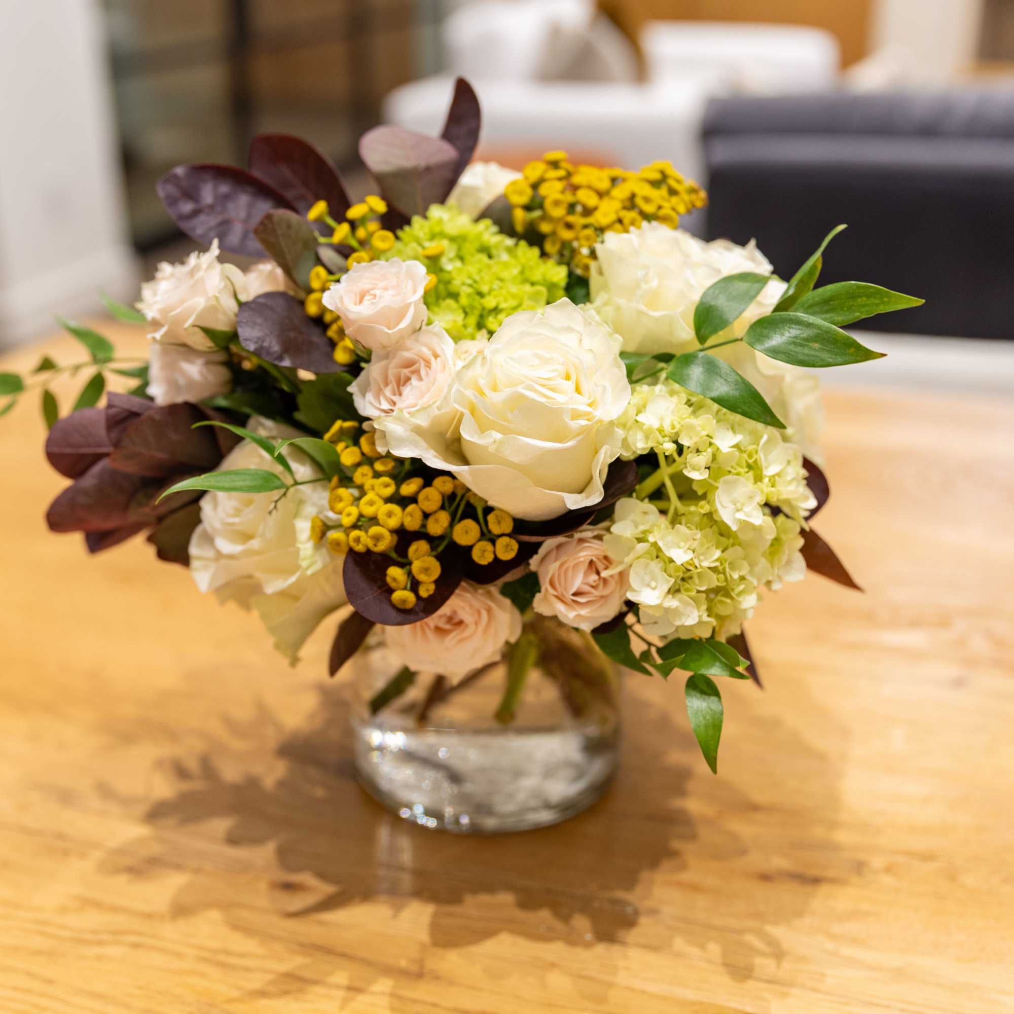 A fresh floral arrangement with season tones and blooms. The perfect centerpiece