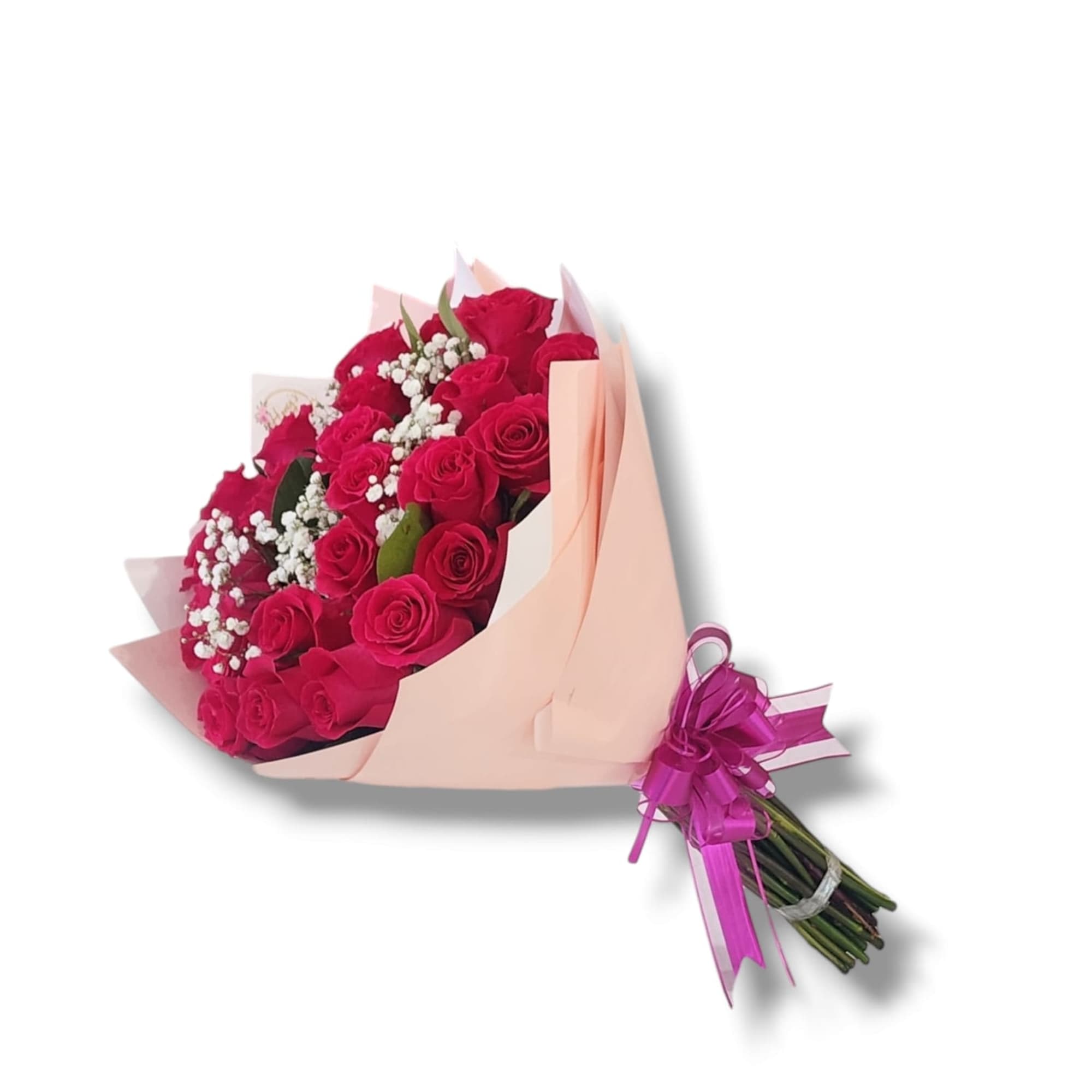 Hand-tied bouquet of hot pink roses and white filler flowers wrapped in peach paper with a pink bow.