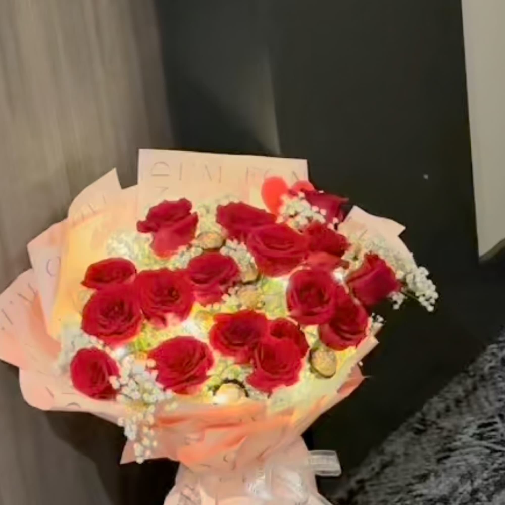 Bouquet of red roses wrapped in pale pink paper