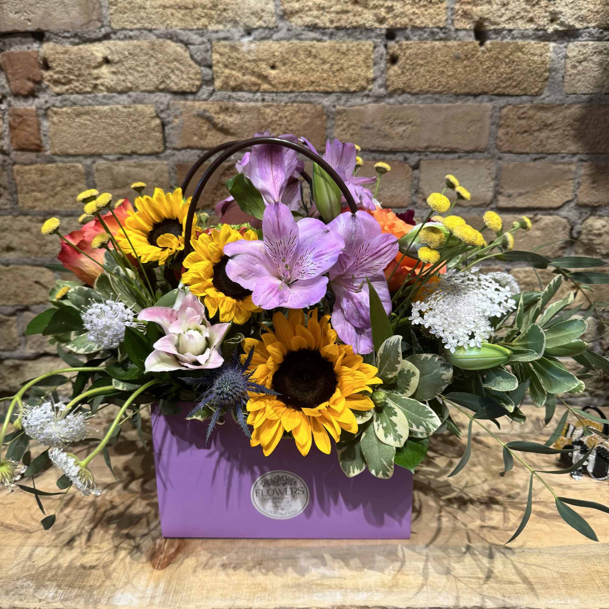 Mixed bouquet in a purple gift box with sunflowers and lavender blooms