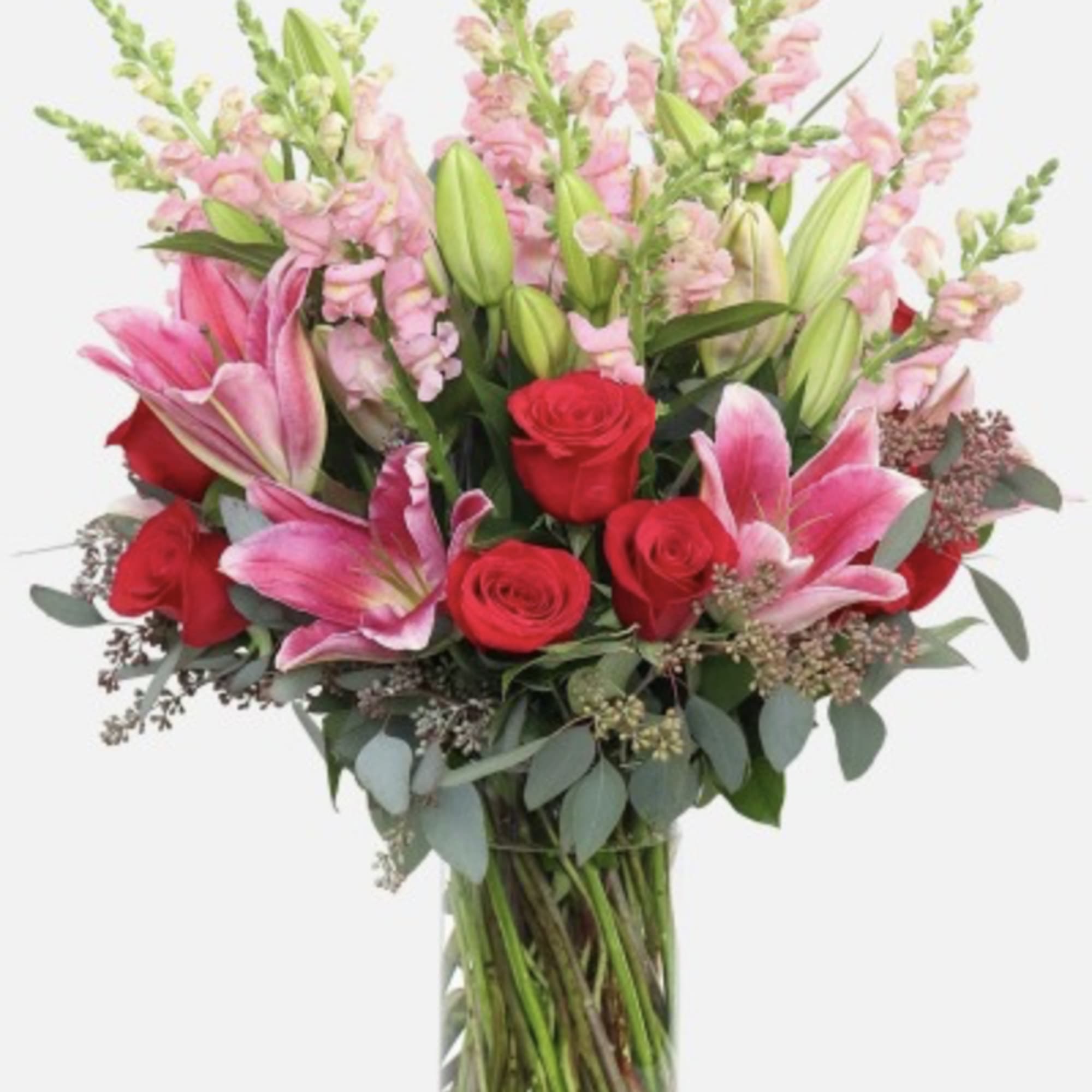 Bouquet of red roses and pink lilies in a clear glass vase