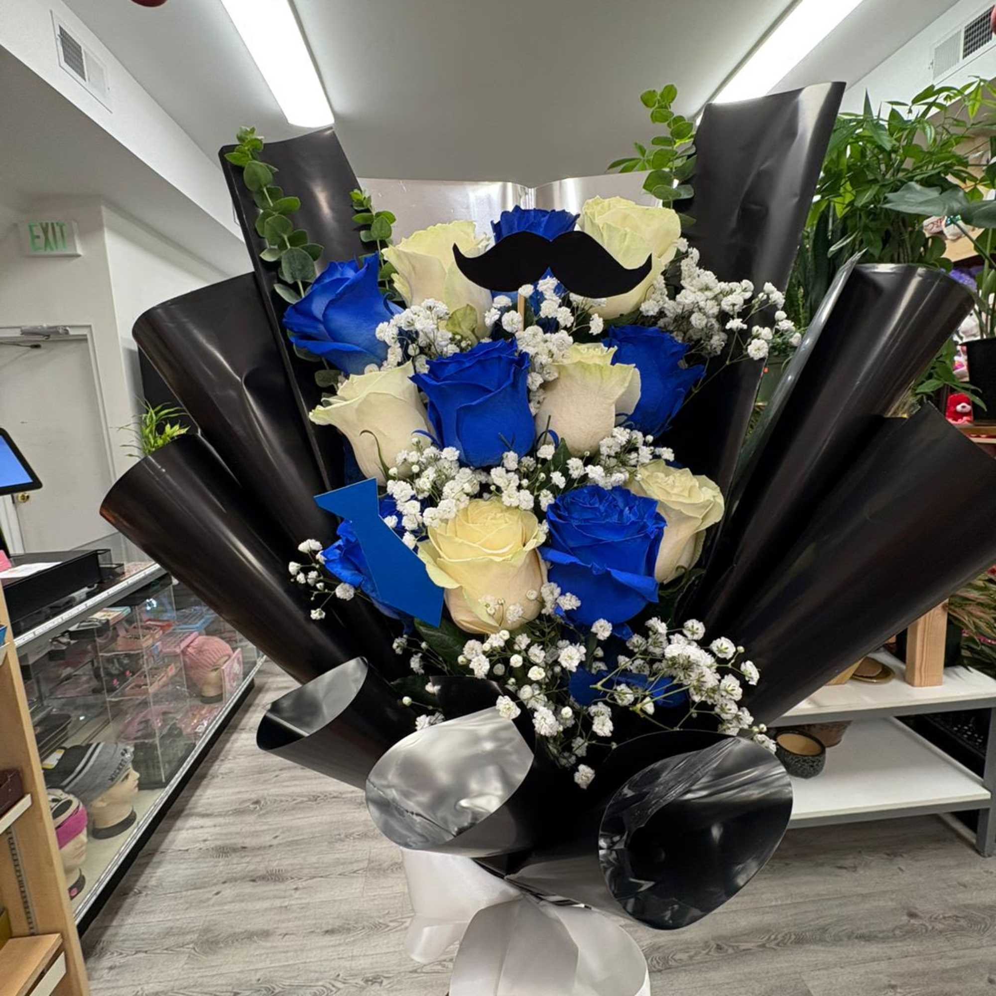 "Gentleman" combines white roses and intense blues, accented with gypsophila details, fresh