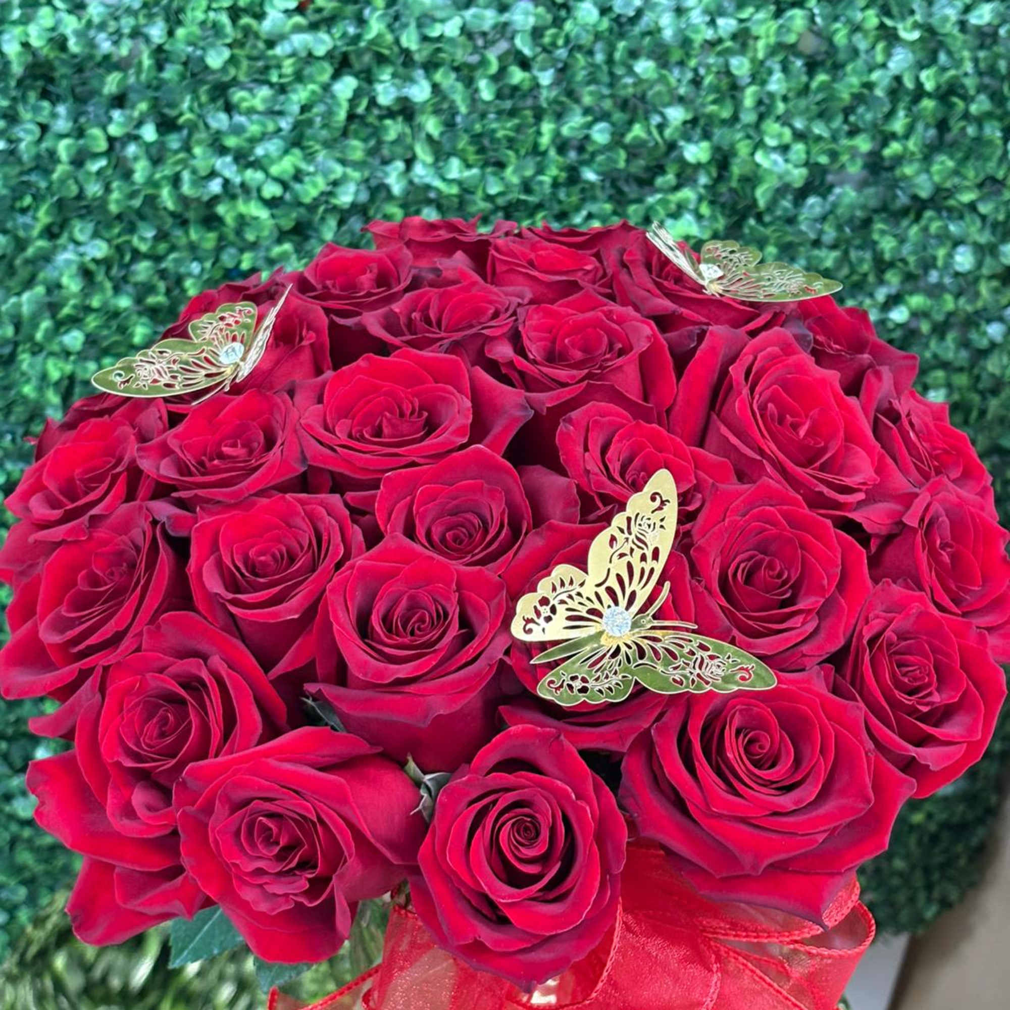 Bouquet of red roses with butterfly decorations and a red ribbon