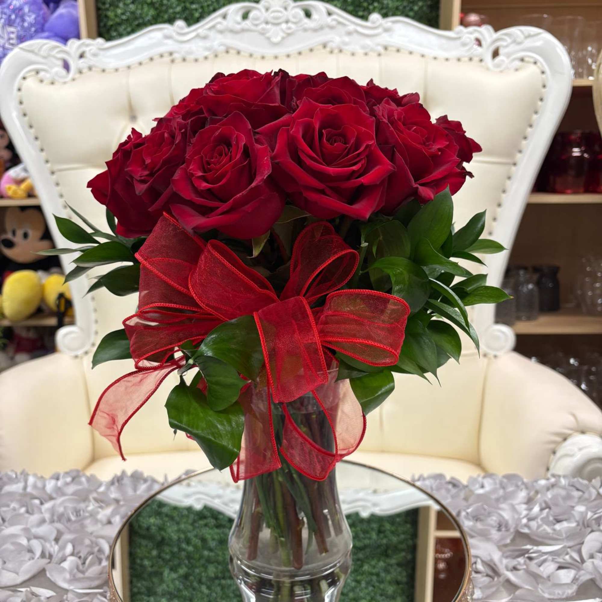 Bouquet of red roses in a clear glass vase with a red ribbon