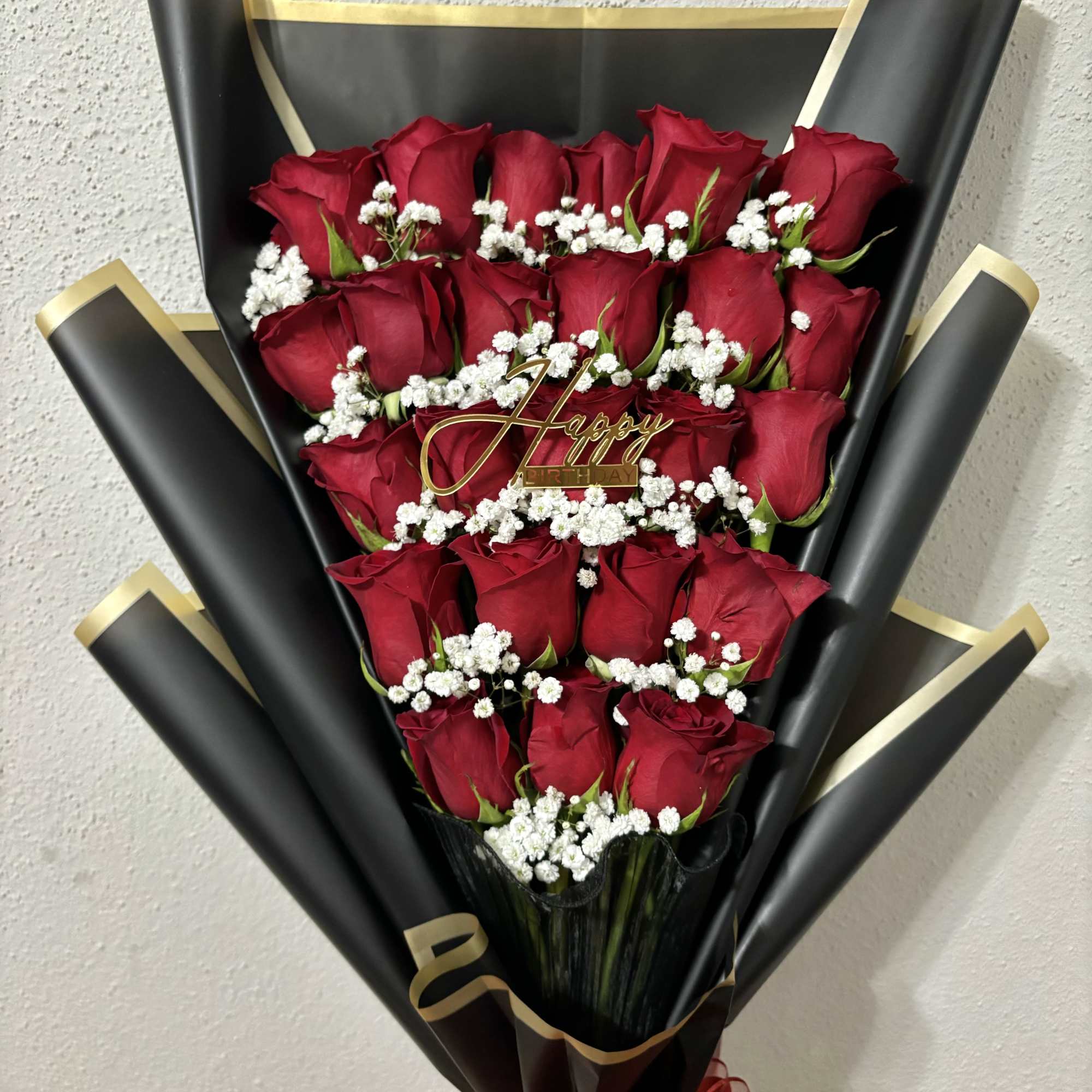 Bouquet of red roses with white baby's breath in black wrap