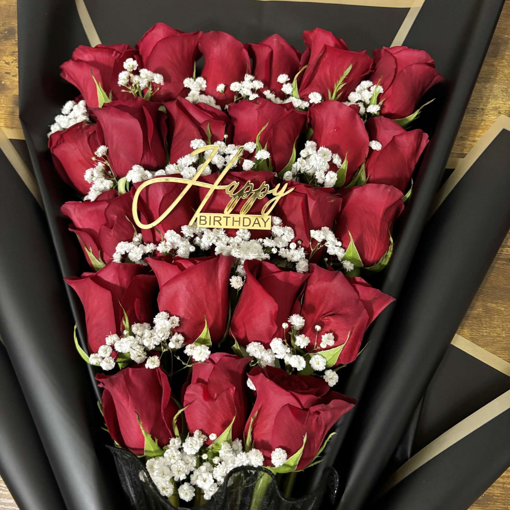 Bouquet of red roses with white baby's breath and a Happy Birthday topper